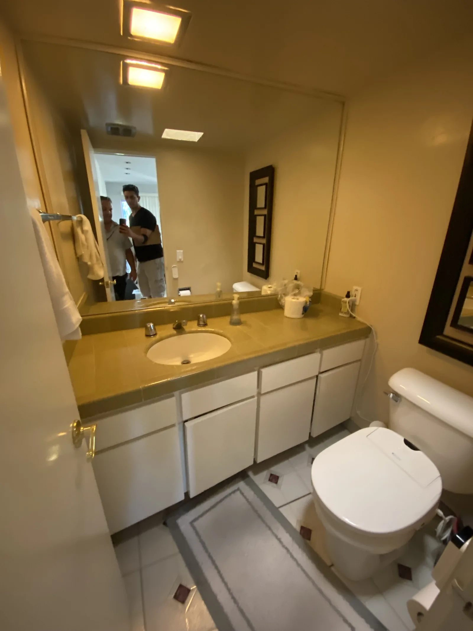 The original vanity before any work began, with a dated tile countertop and oval drop-in sink
