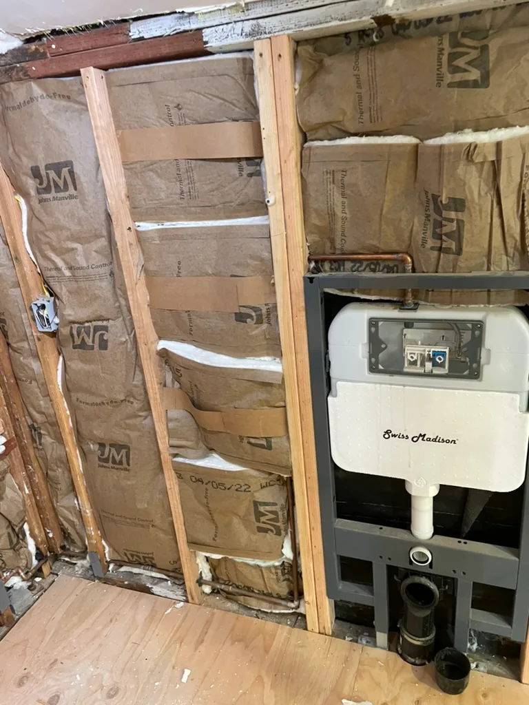 An in-wall toilet tank and frame set into new insulated bathroom framing