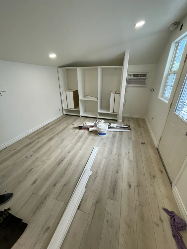 Built-in closet cabinets being assembled on the bedroom wall beside the air conditioner