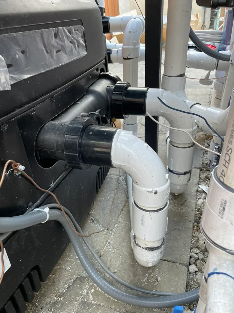The pool heater with new white plumbing connections