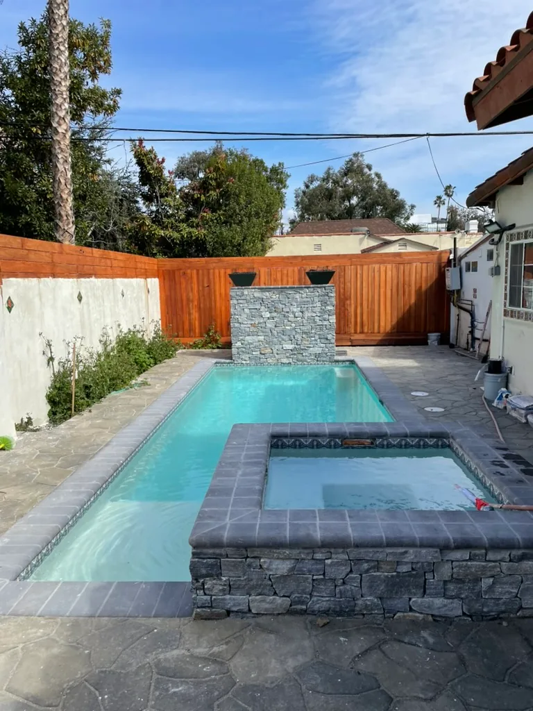 The finished pool and raised stone spa, looking toward the waterfall wall