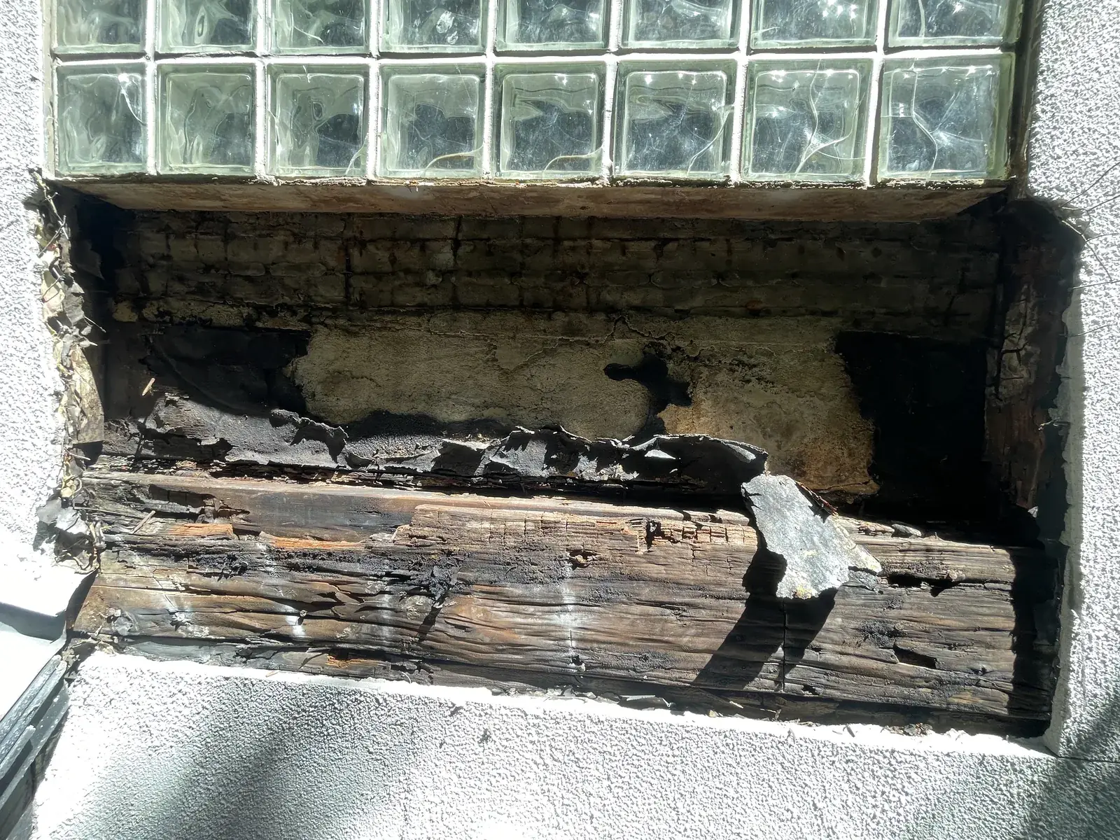 The cavity below a second-floor window opened up, showing extensive wood rot