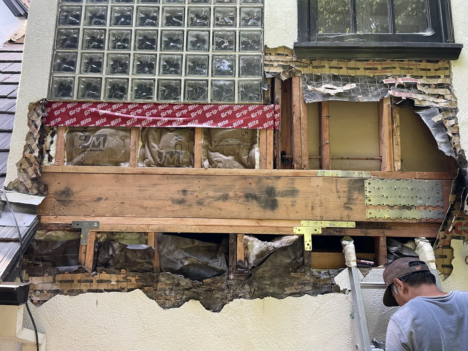 New framing at a window base with flashing tape applied around the stud bay