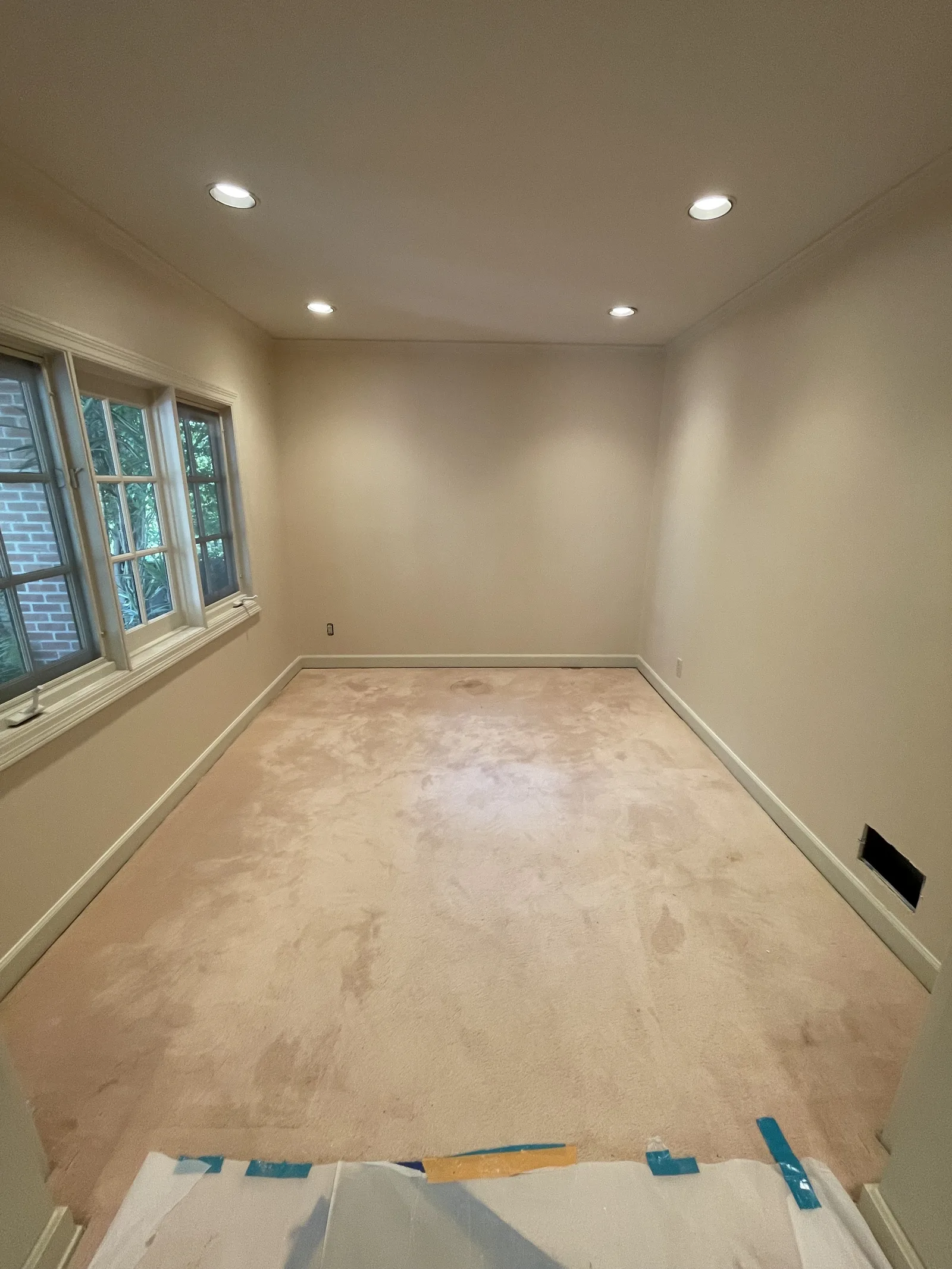 A room with smooth walls and carpet pad down, ready for paint