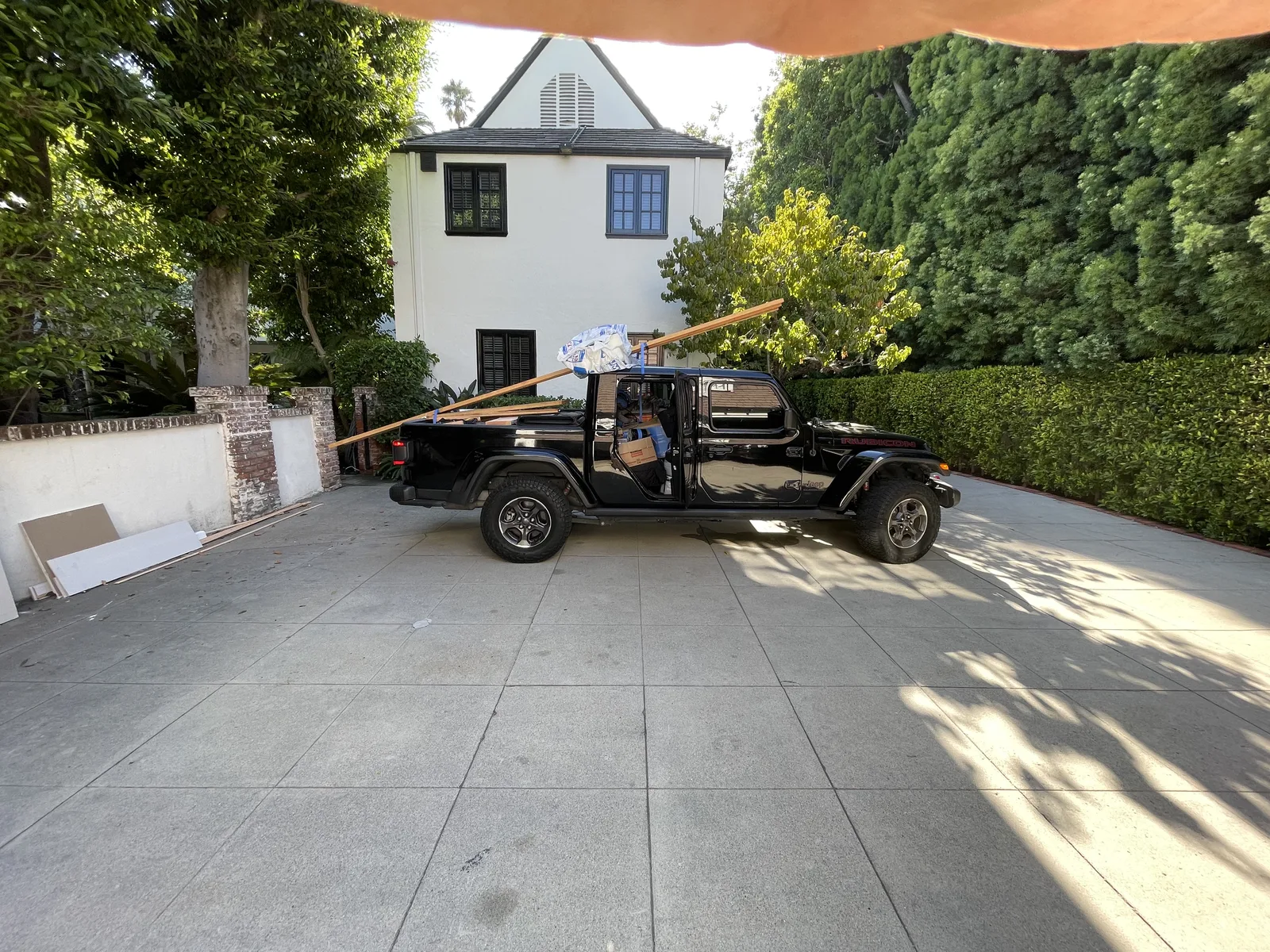 A truck loaded with materials parked in the driveway outside the house