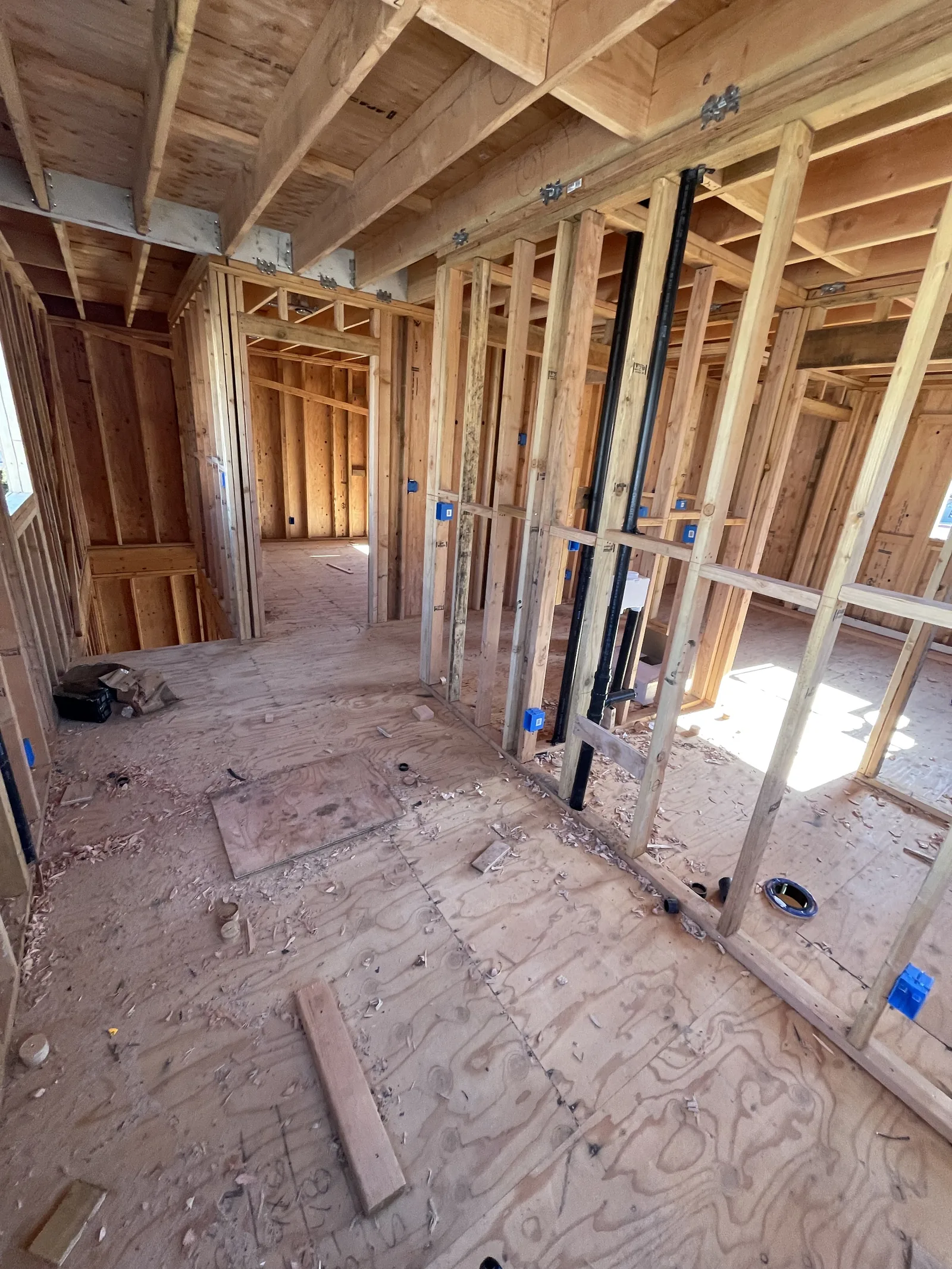 New wood framing on a second floor with plumbing stub-outs and electrical boxes in place