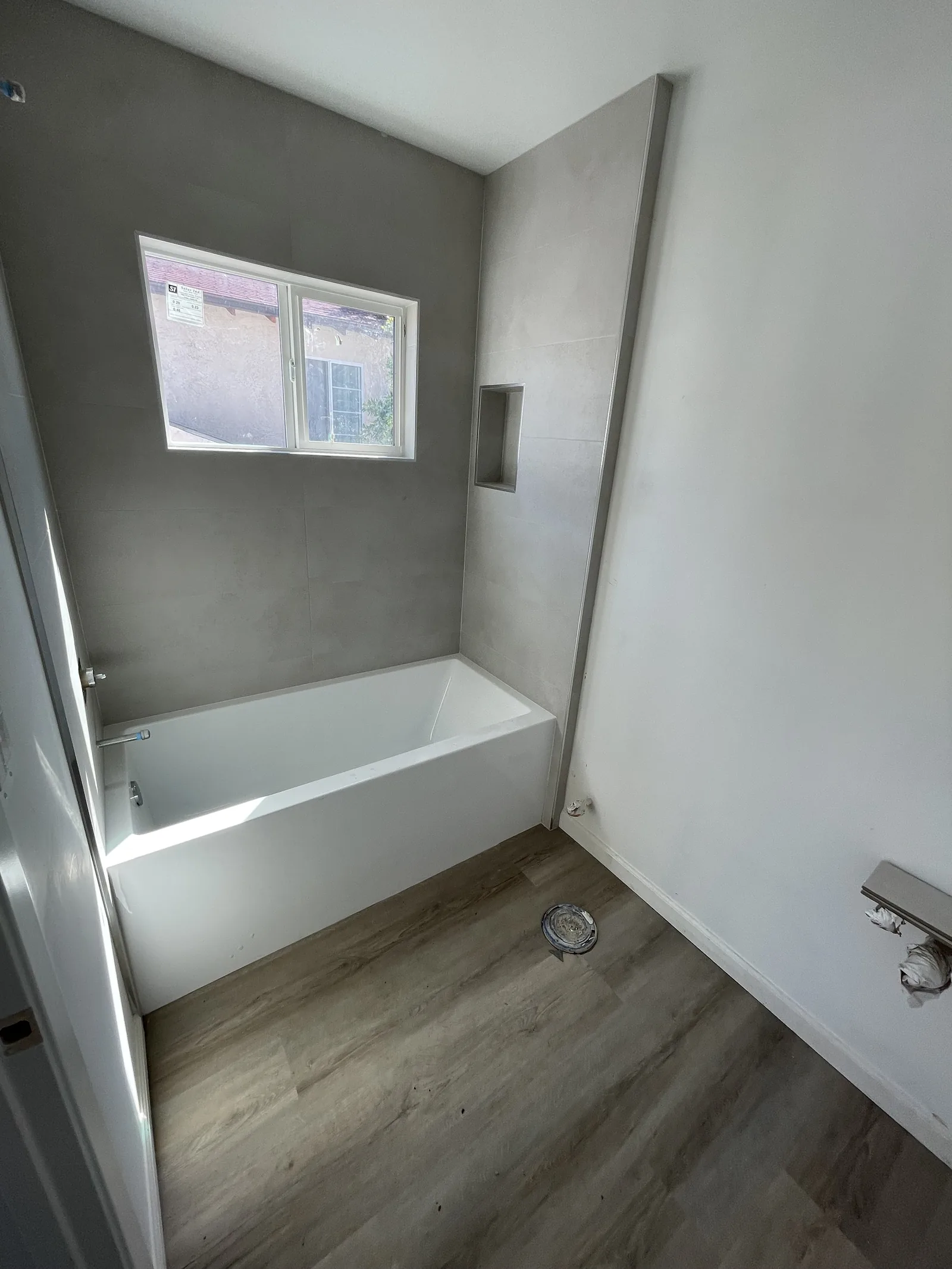 A near-finished bathroom with a freestanding tub and gray tile