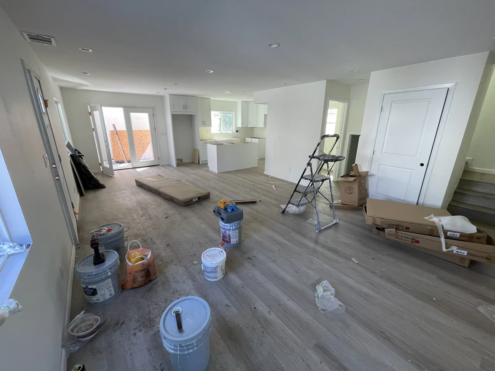 A wide view of an open-concept living, dining, and kitchen area near completion