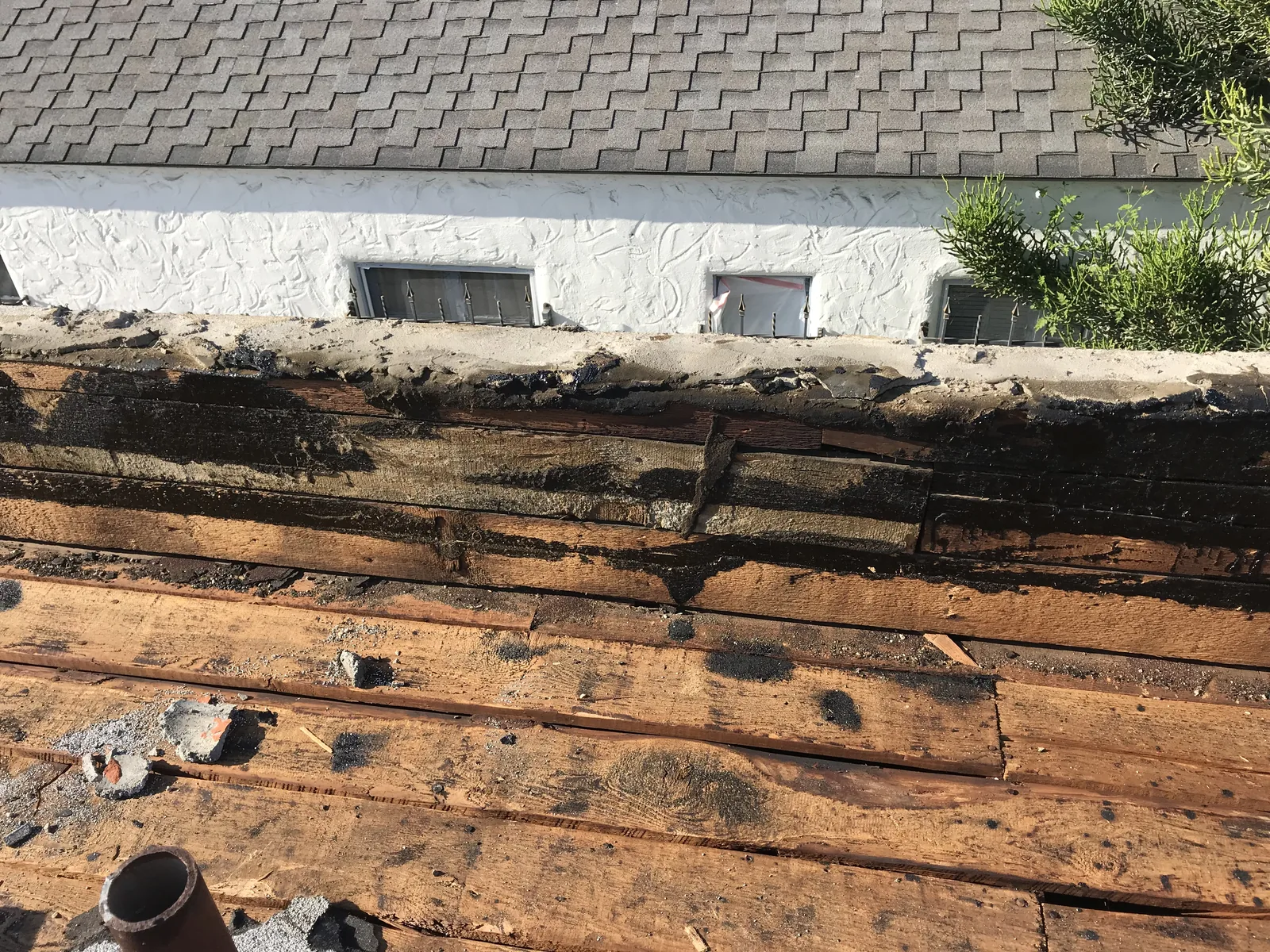 A close view of the parapet wall stripped down to the old roof decking