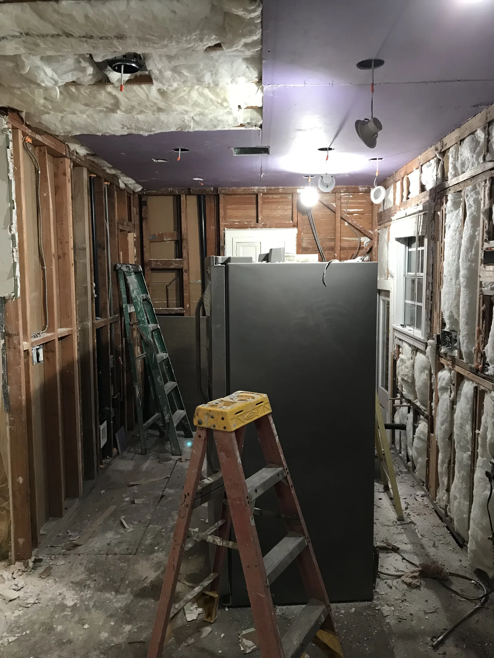 The kitchen stripped to the studs, with new wiring and insulation and recessed light cans installed