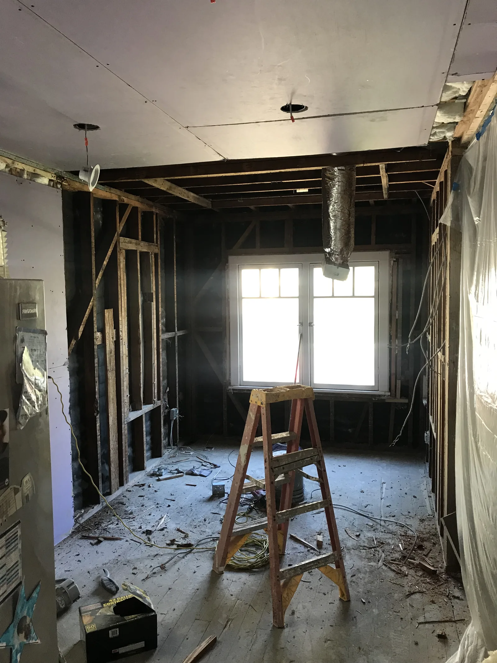 A new window installed with a new HVAC duct run through the open ceiling