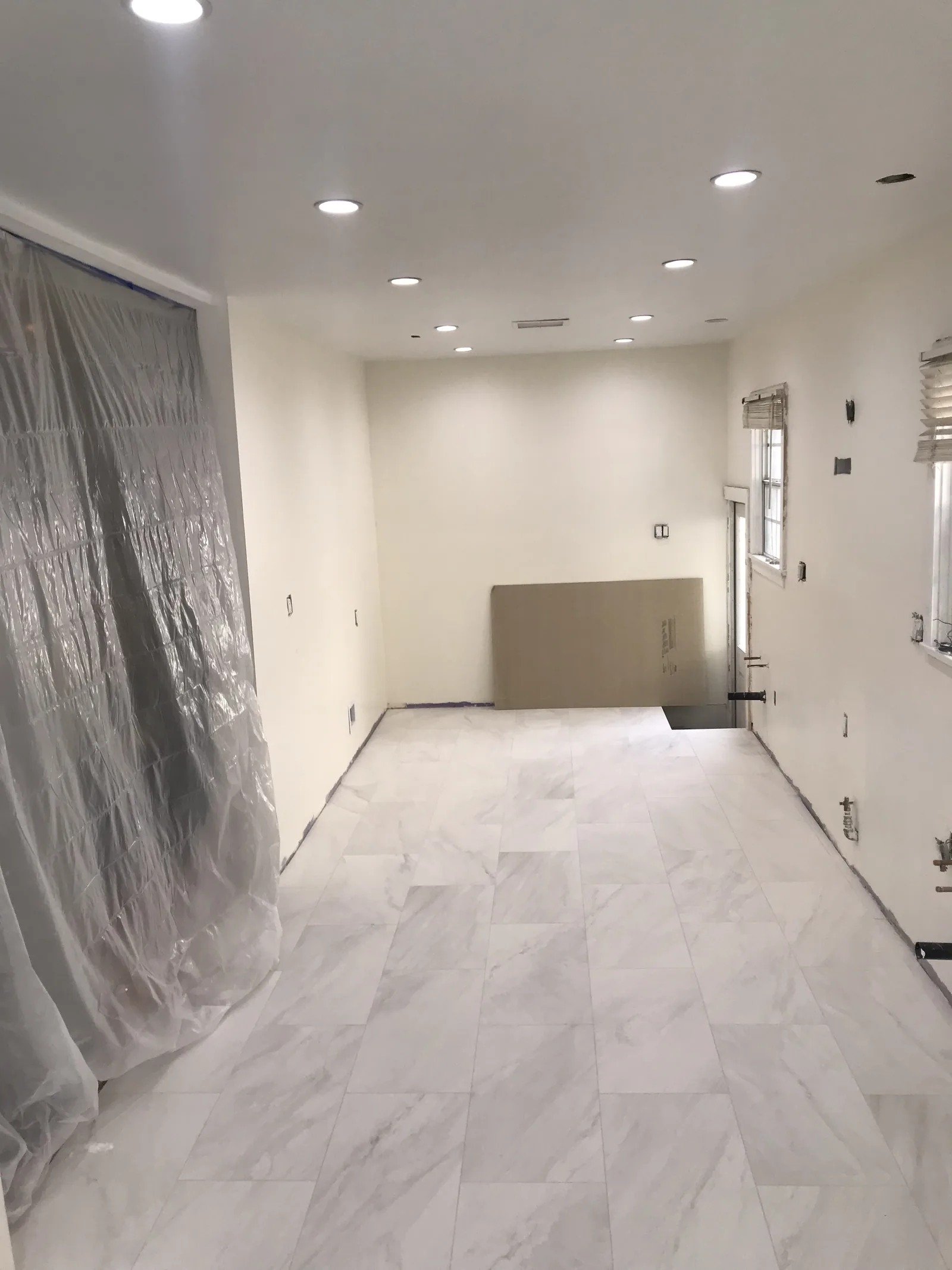 The kitchen floor tile finished, with a new window and recessed lighting installed