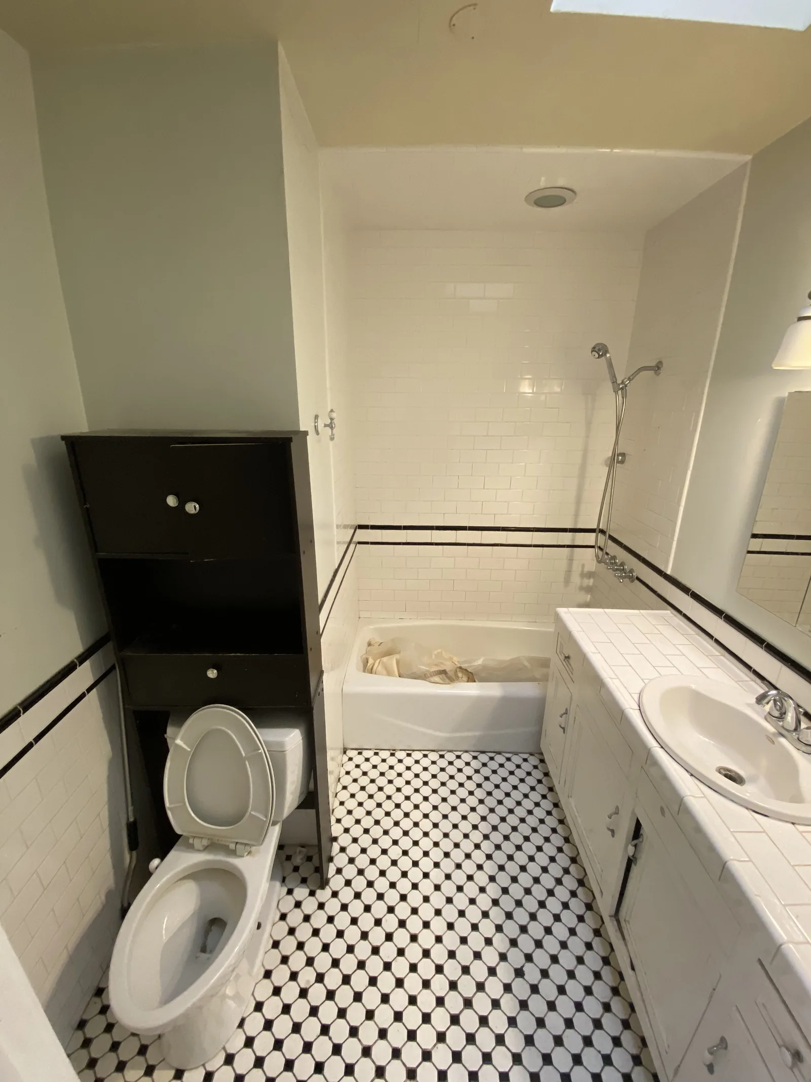 The original bathroom before any work began, with black and white hexagonal floor tile
