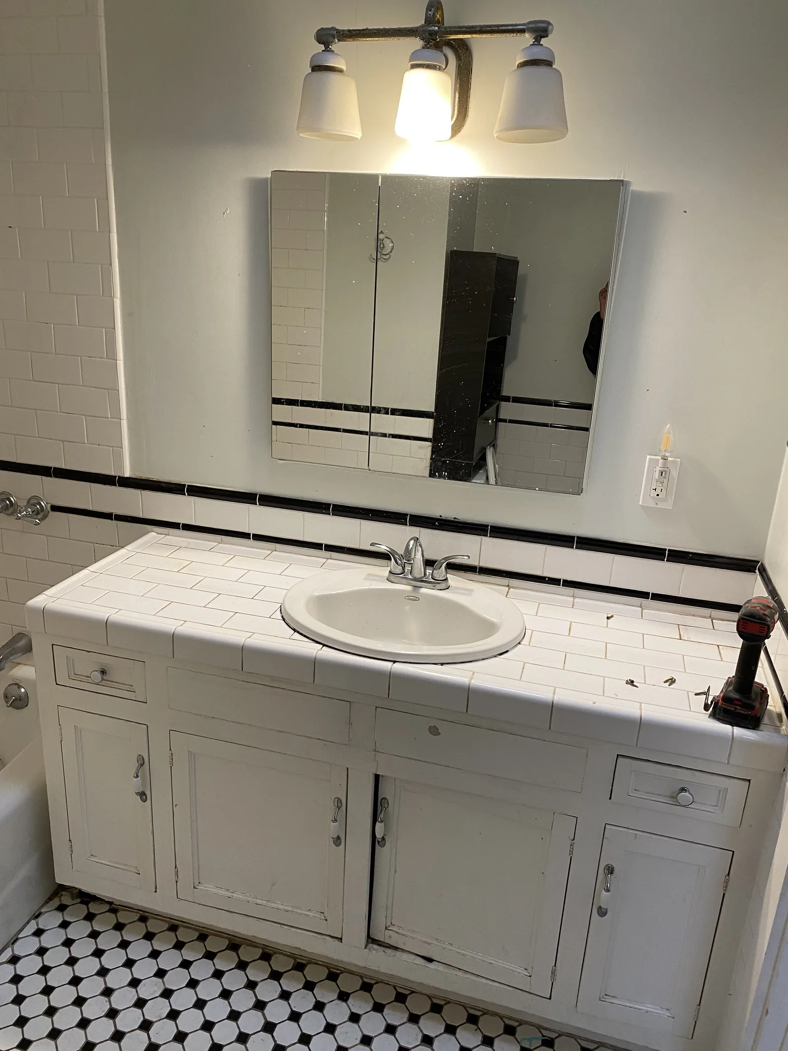 The original vanity, mirror cabinet, and light fixture before demolition