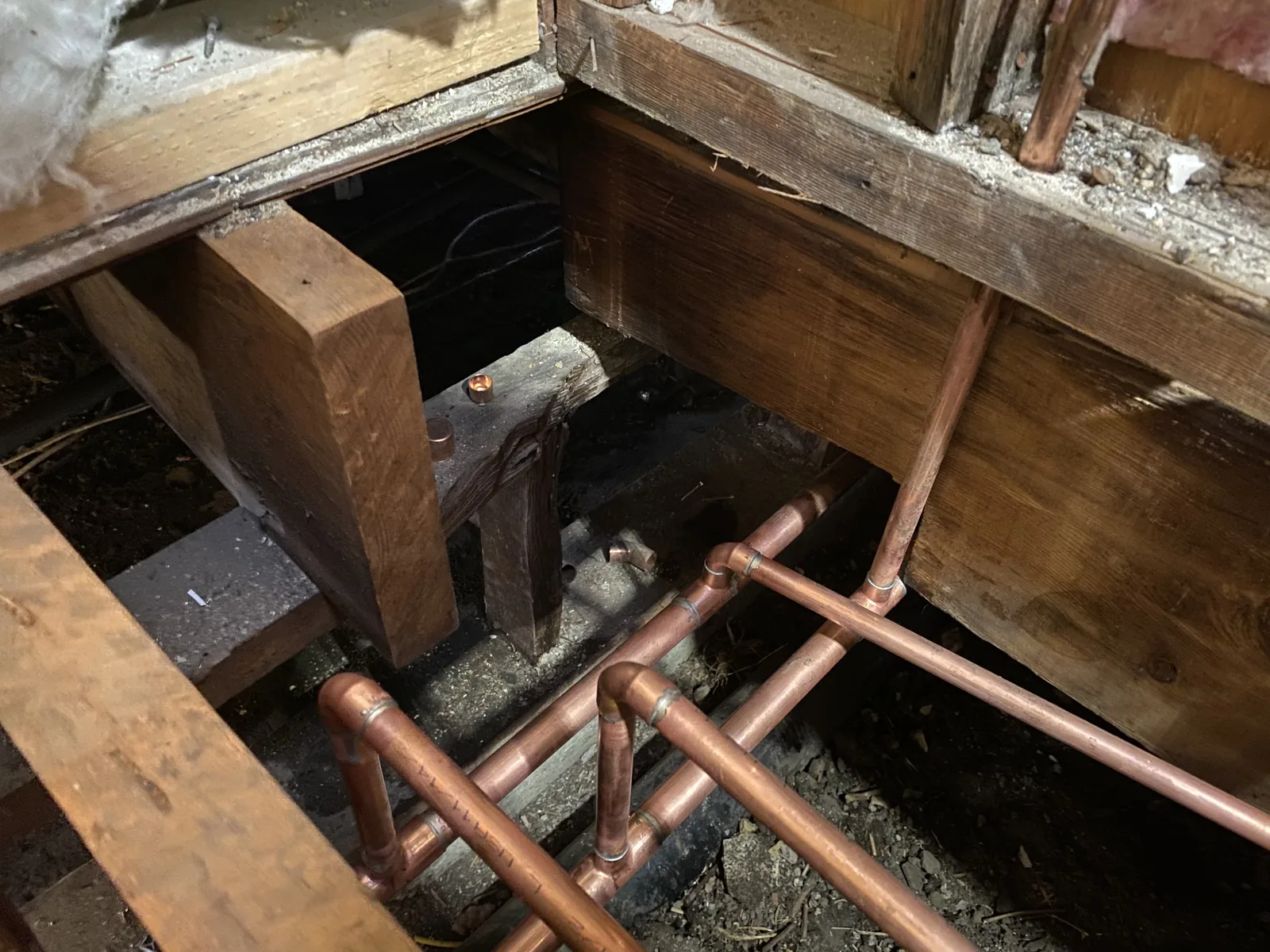 New copper supply pipes run beneath the house during the repipe
