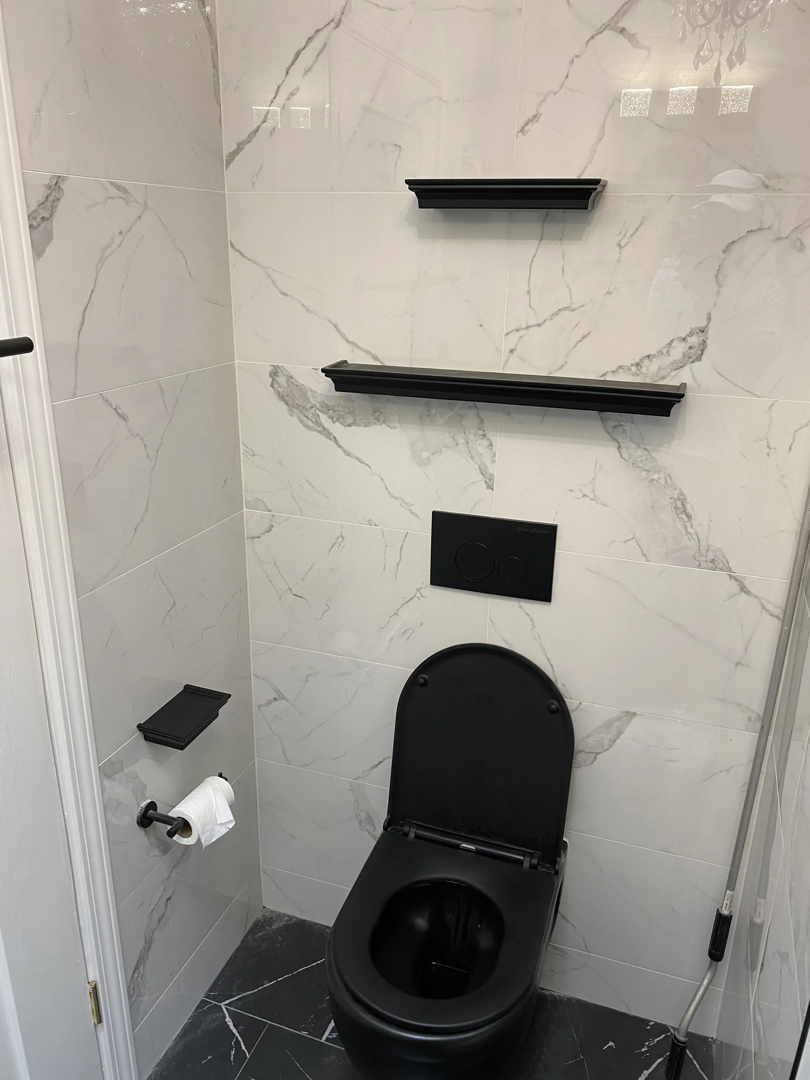 A matte black wall-mounted toilet on its concealed carrier
