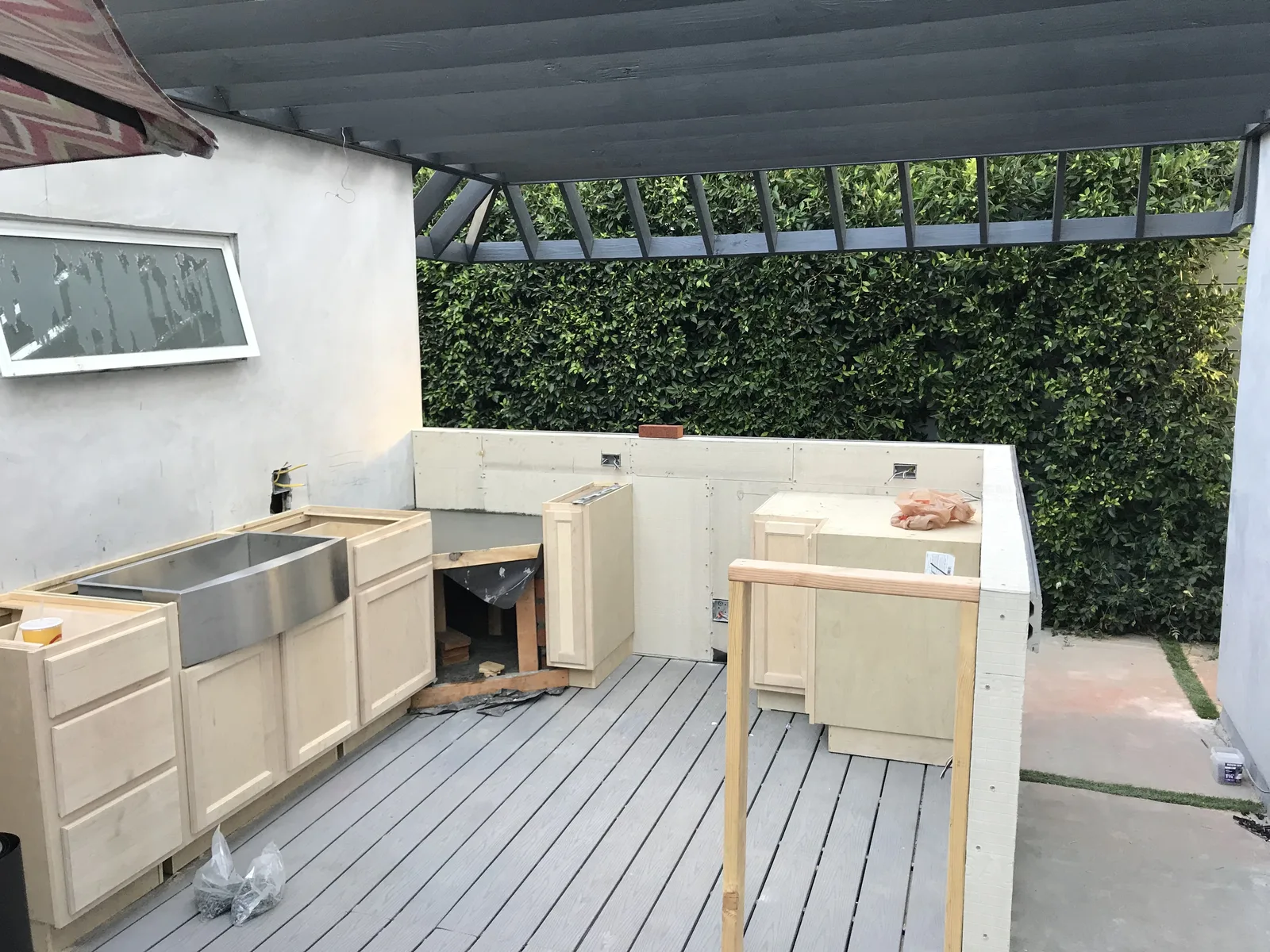 Kitchen cabinet boxes and a sink installed, with an oven cavity opening framed in