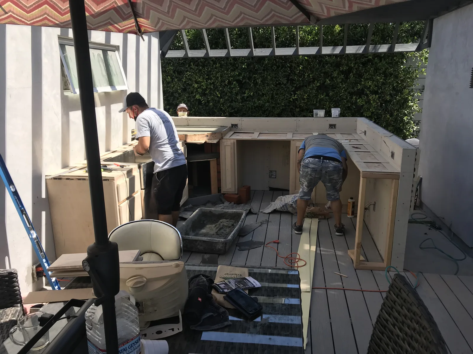 Workers assembling outdoor kitchen cabinet boxes