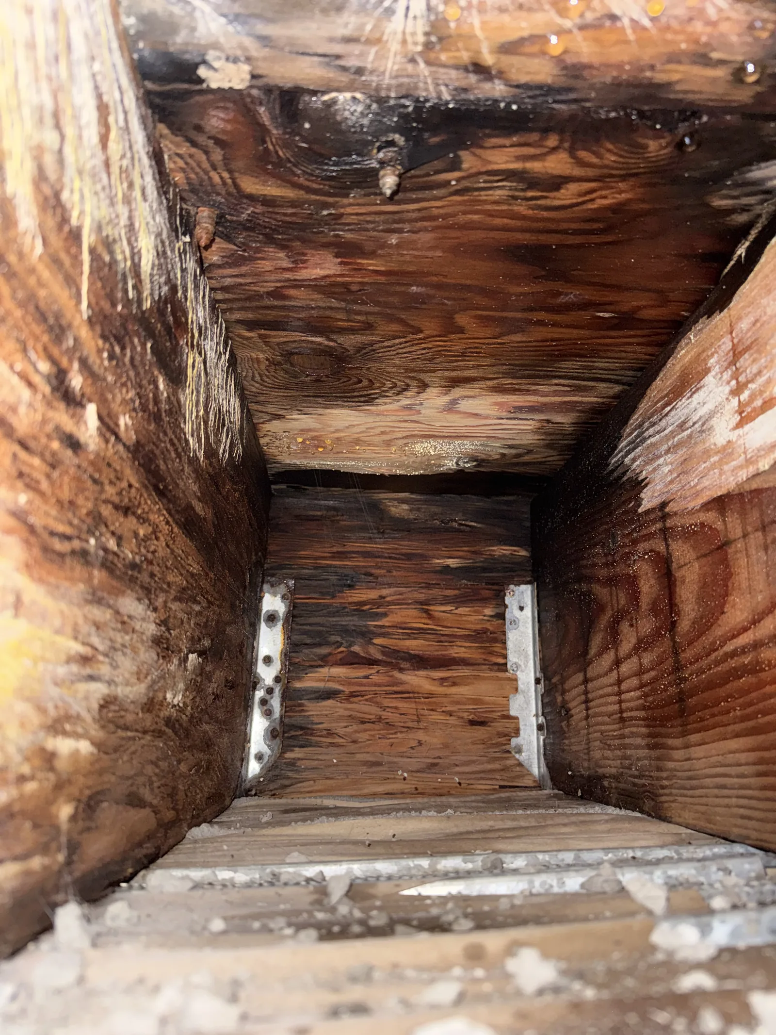 The inside of an opened wall cavity with severely rotted wood framing