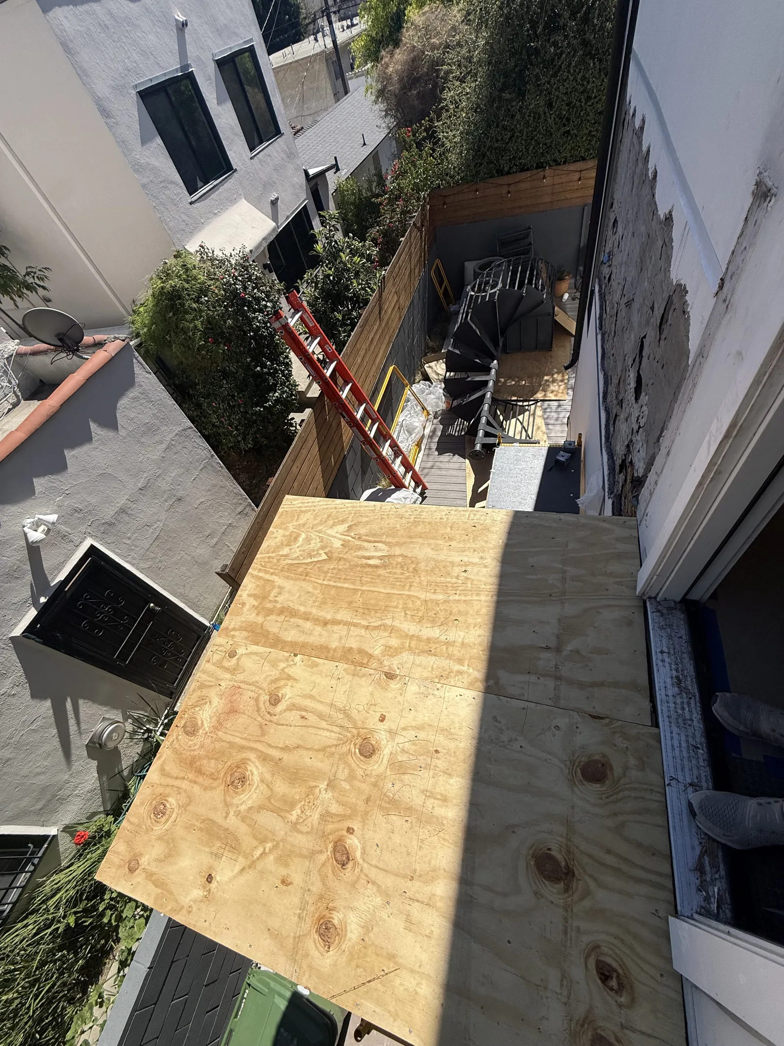 An aerial view looking straight down at a plywood panel staged on the roof