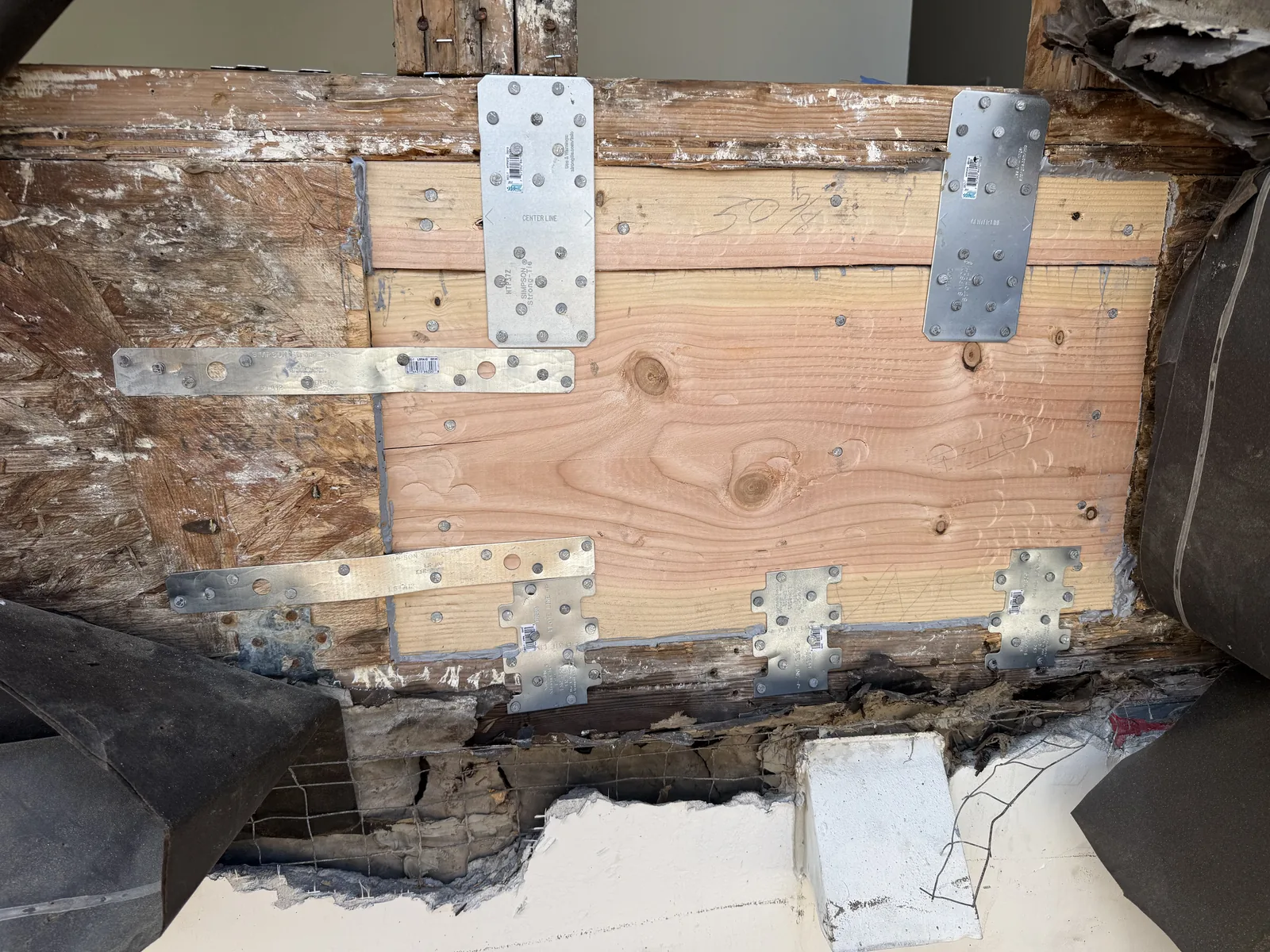 Galvanized joist hardware and straps reinforcing new framing