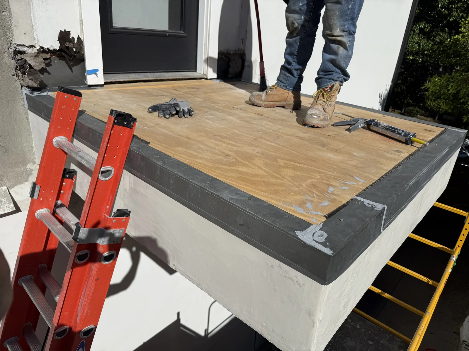 The new plywood deck surface with the waterproof edge membrane already applied around the perimeter