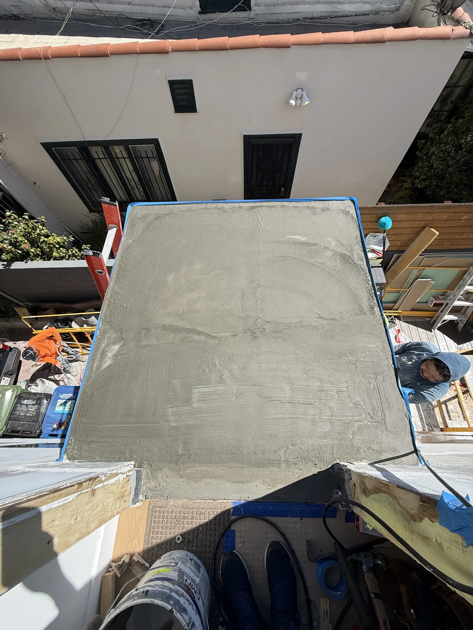 The completed gray waterproof deck surface seen from above, with a drain visible