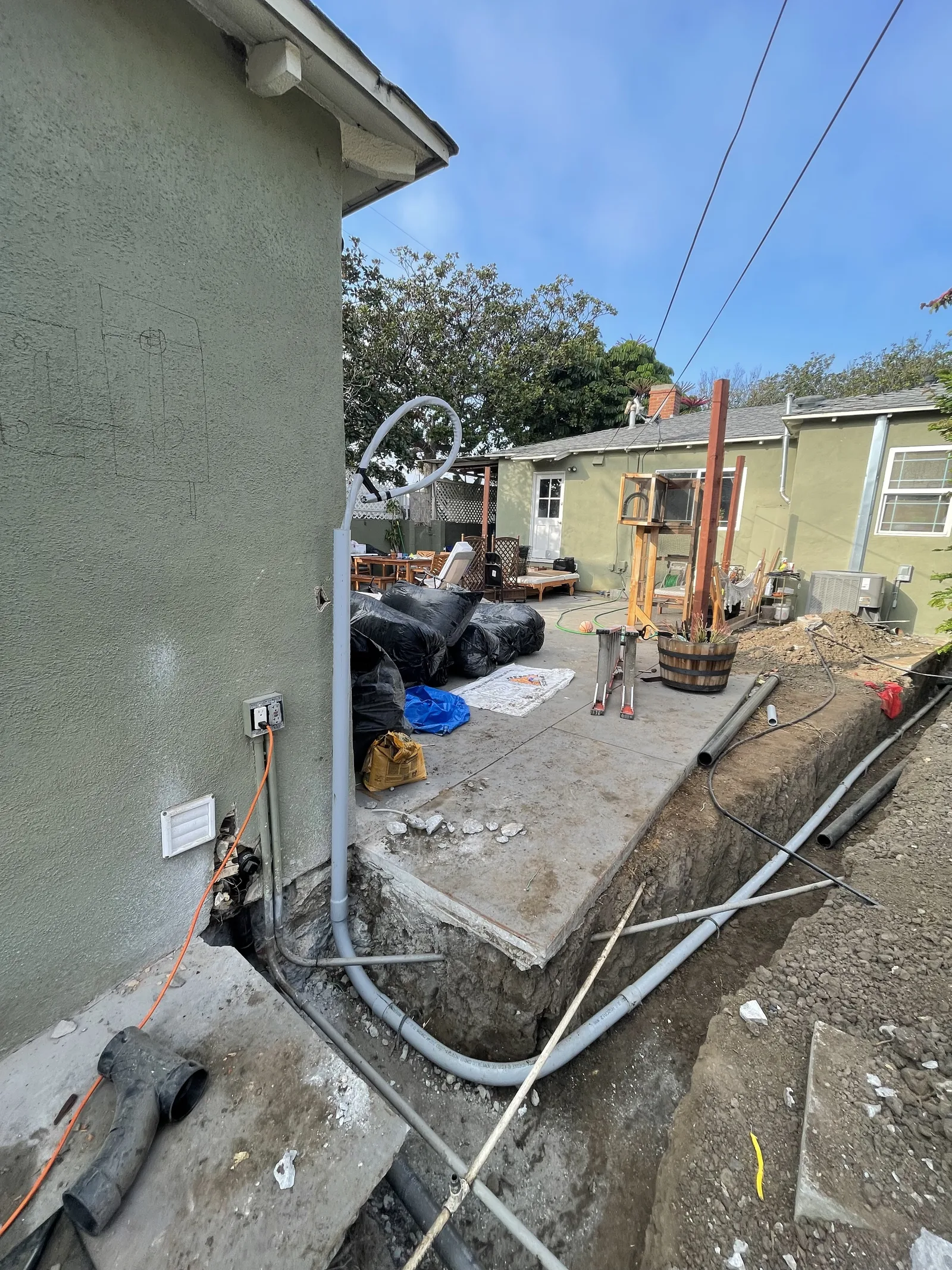 New electrical conduit running along a foundation into a utility trench