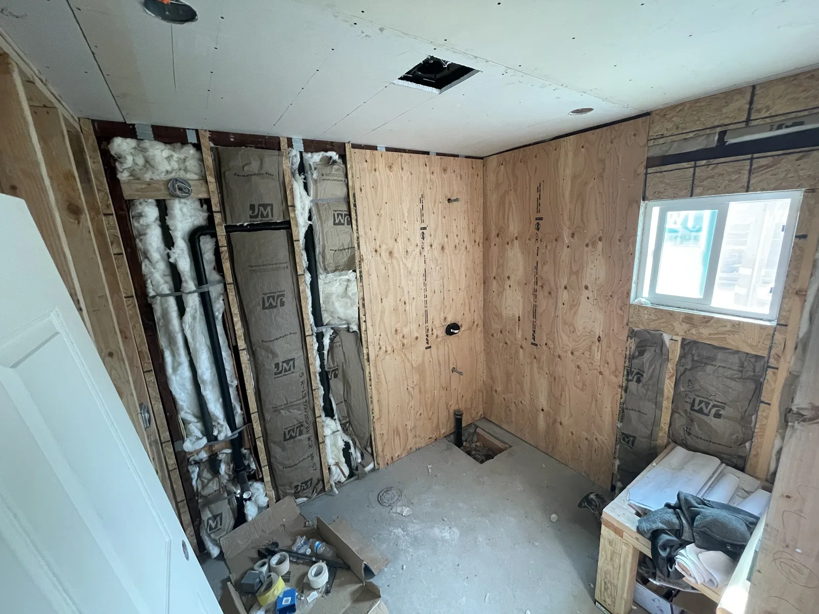 Wall insulation and plumbing rough-in for a bathroom wall