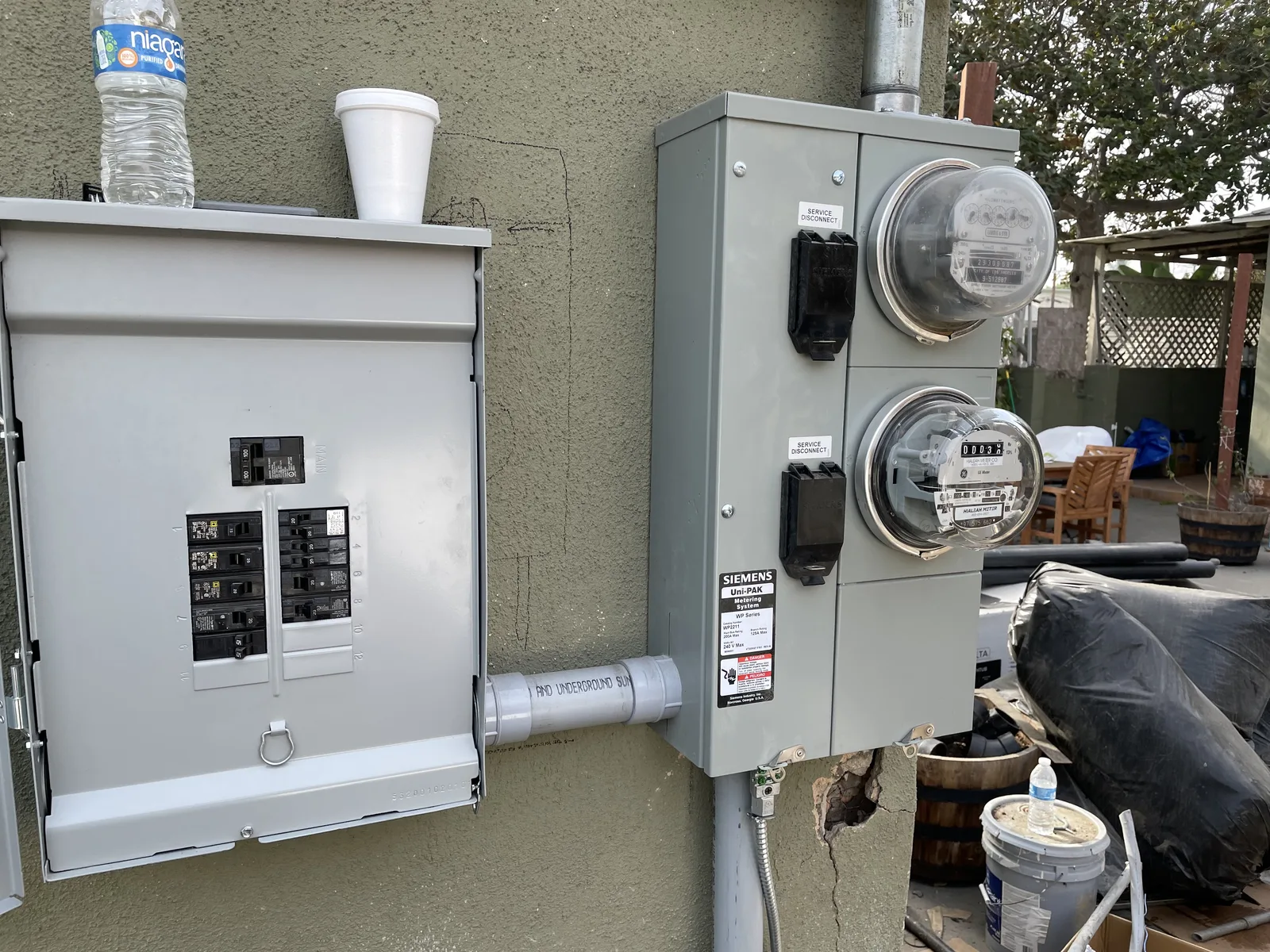 A new electrical panel and two utility meters mounted on an exterior wall