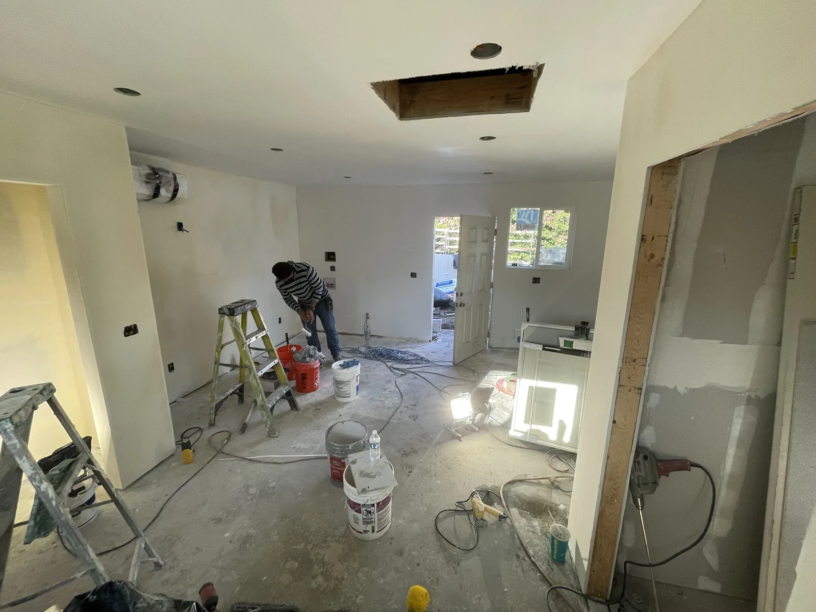 Painted walls in a living area, with a toilet staged on the floor before installation