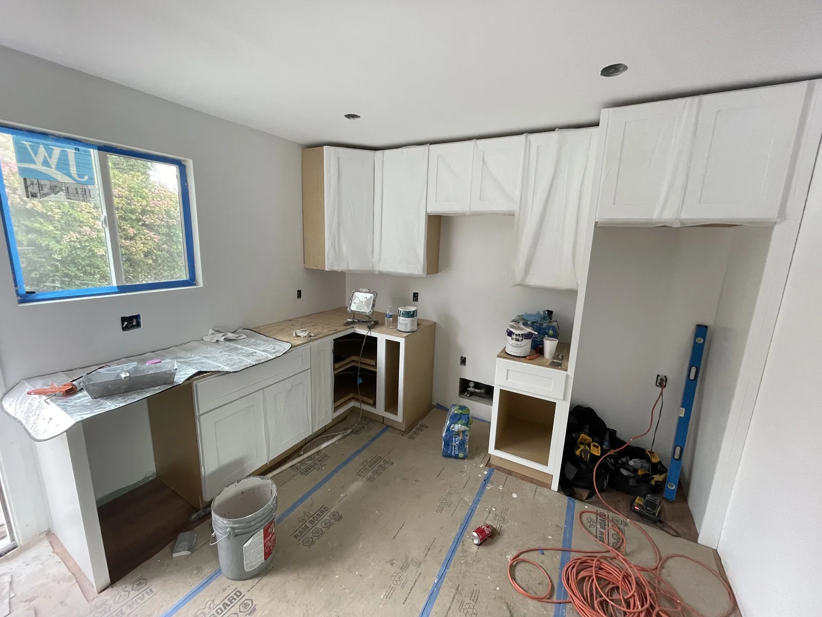 Upper and lower white kitchen cabinets installed along one wall