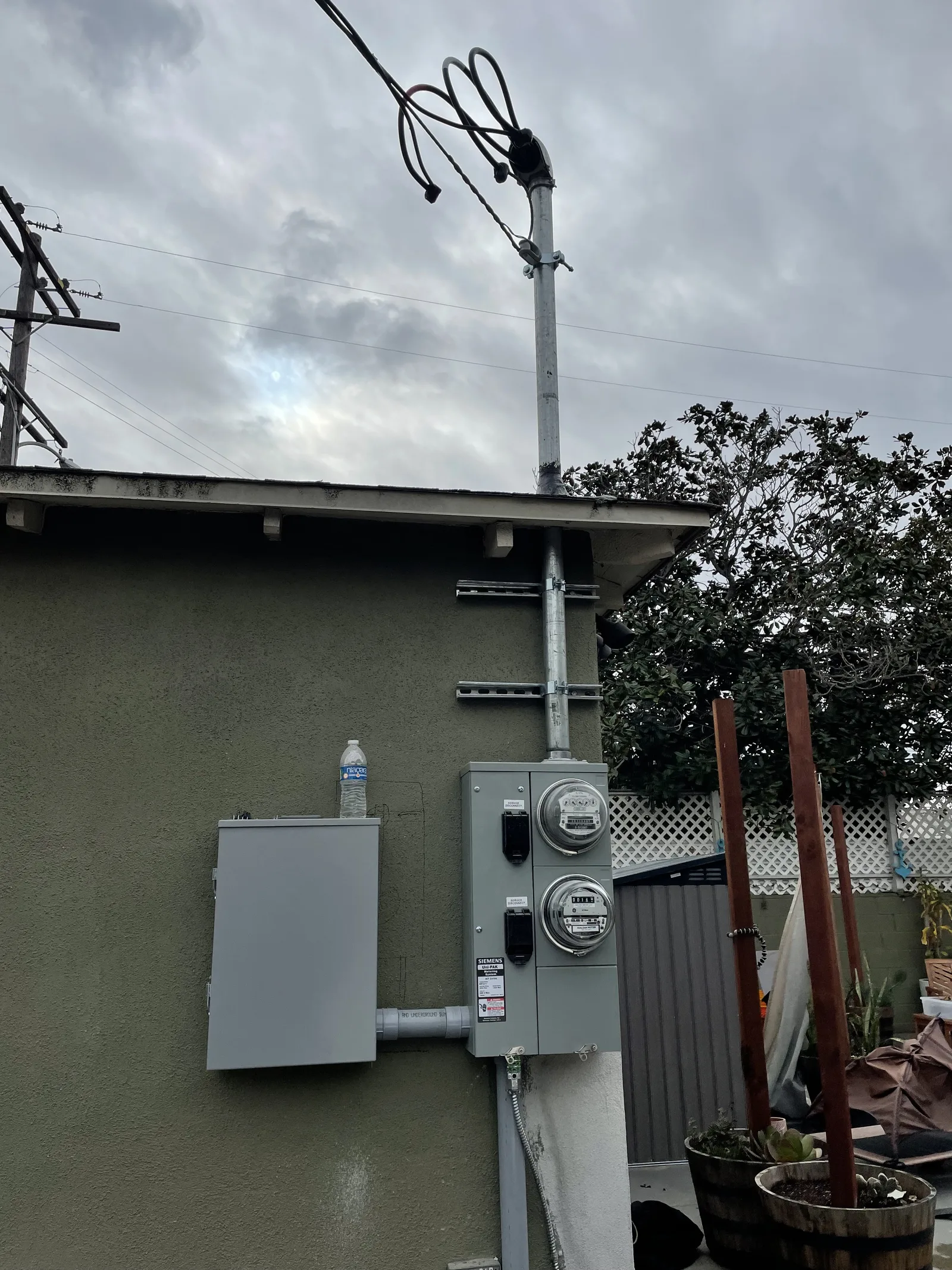 A new electrical service mast and meter panel on an exterior wall