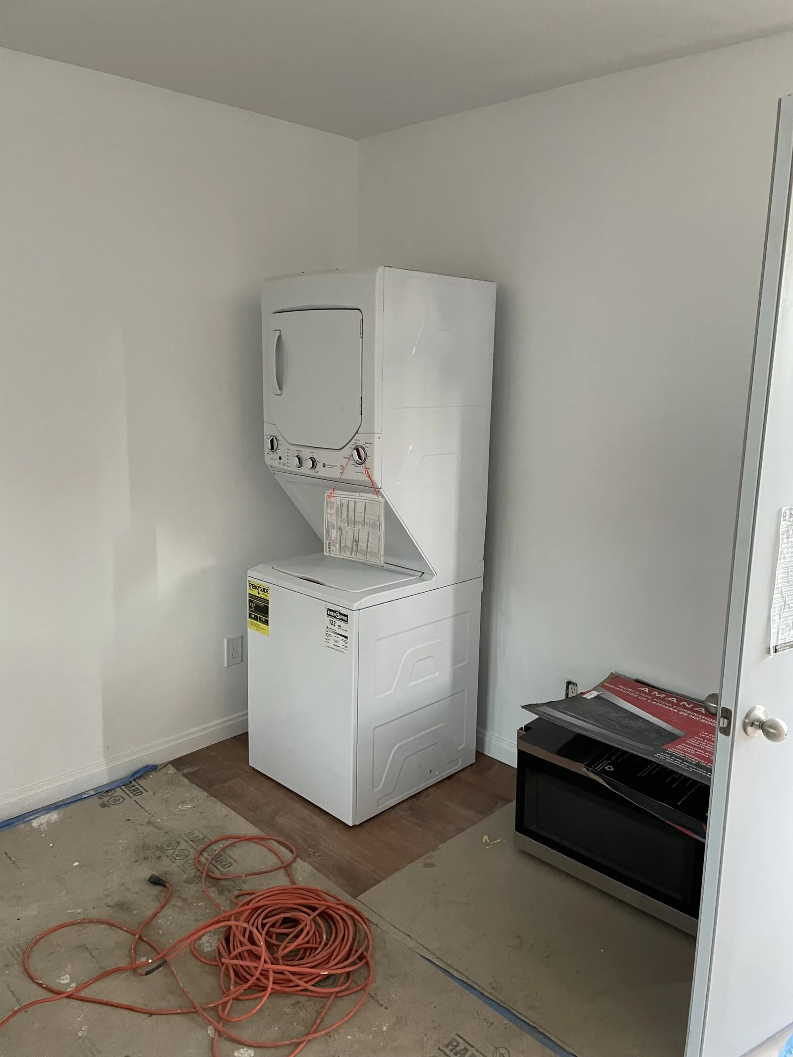 A stacked washer and dryer installed in a laundry closet