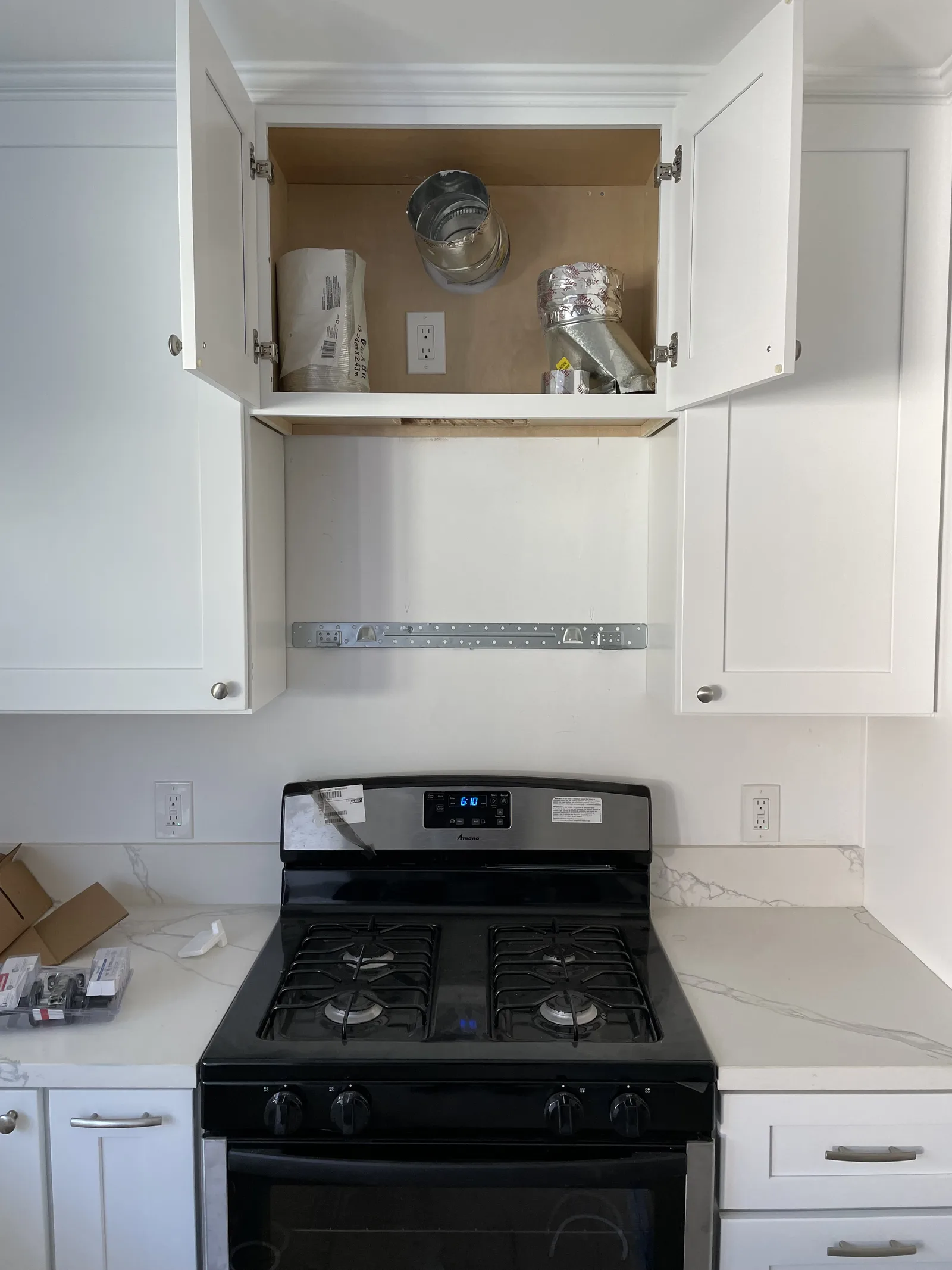 A range hood being installed above a kitchen range