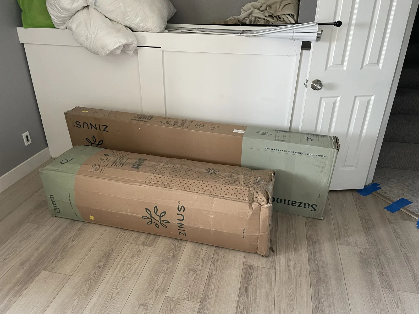 A finished hallway with flooring and trim, with moving boxes on the floor