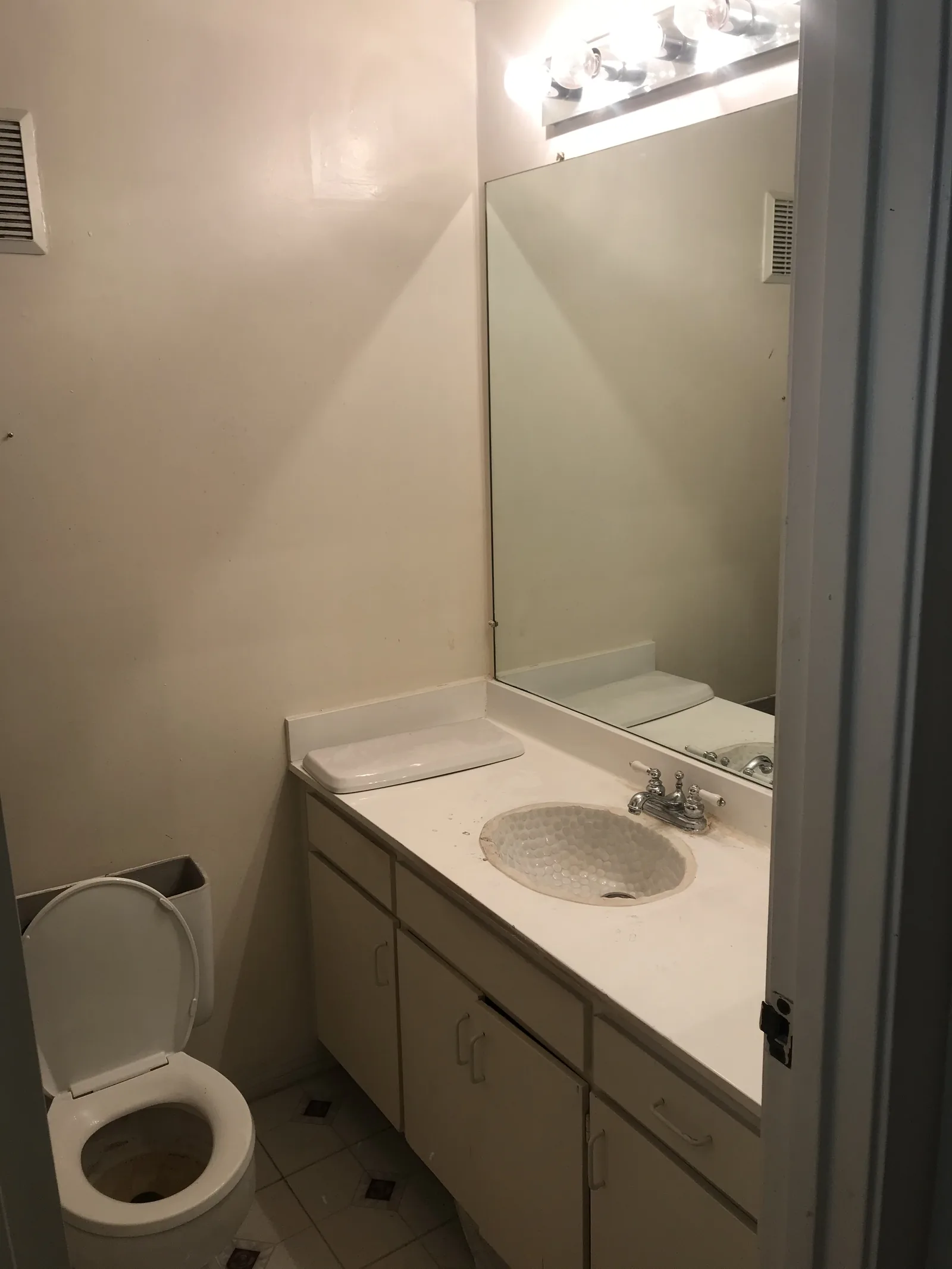 The original bathroom before the remodel, with an oval drop-in sink and a low-profile toilet