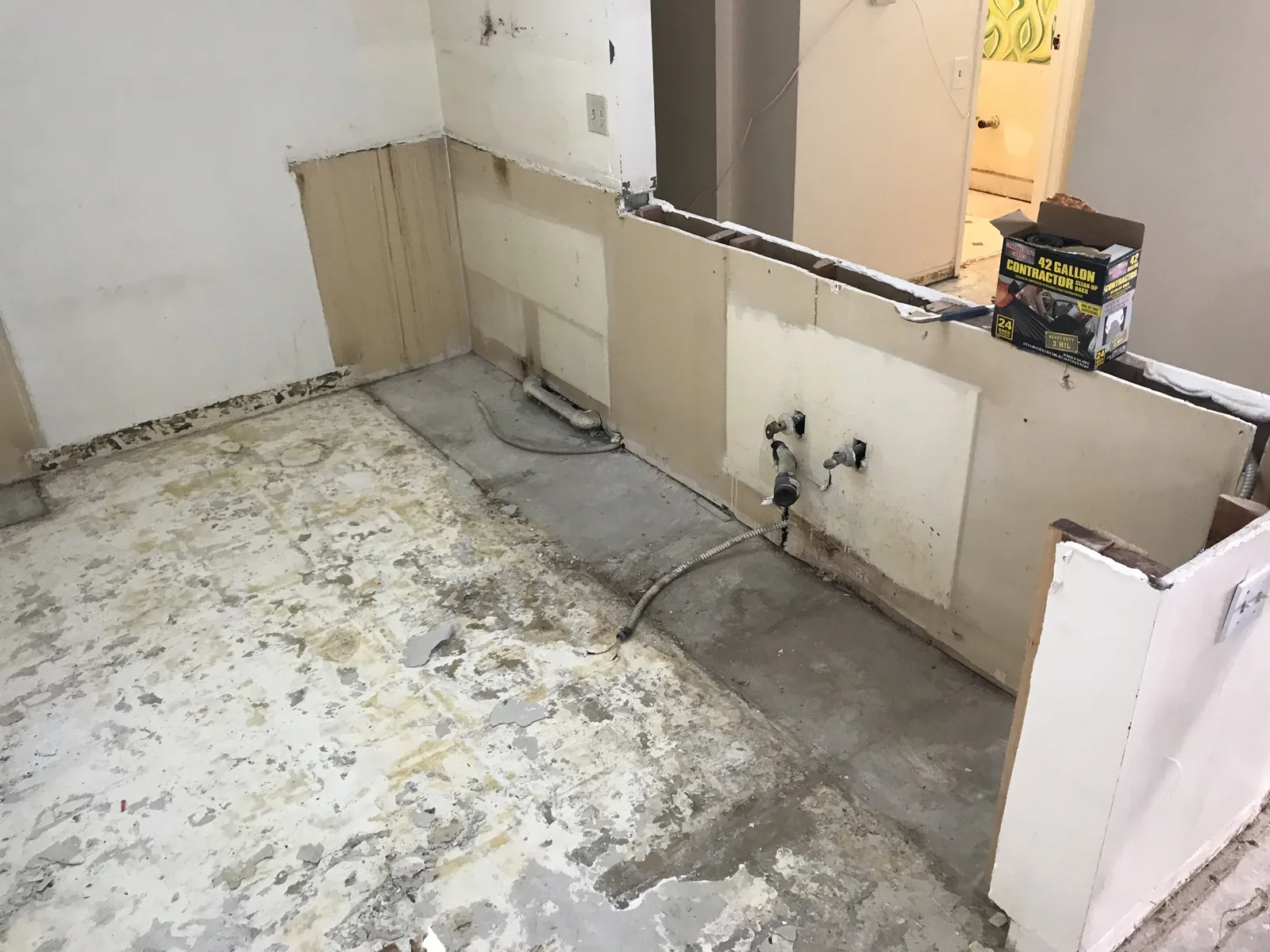 A close view of a stripped kitchen wall with wiring exposed where the cabinets used to be