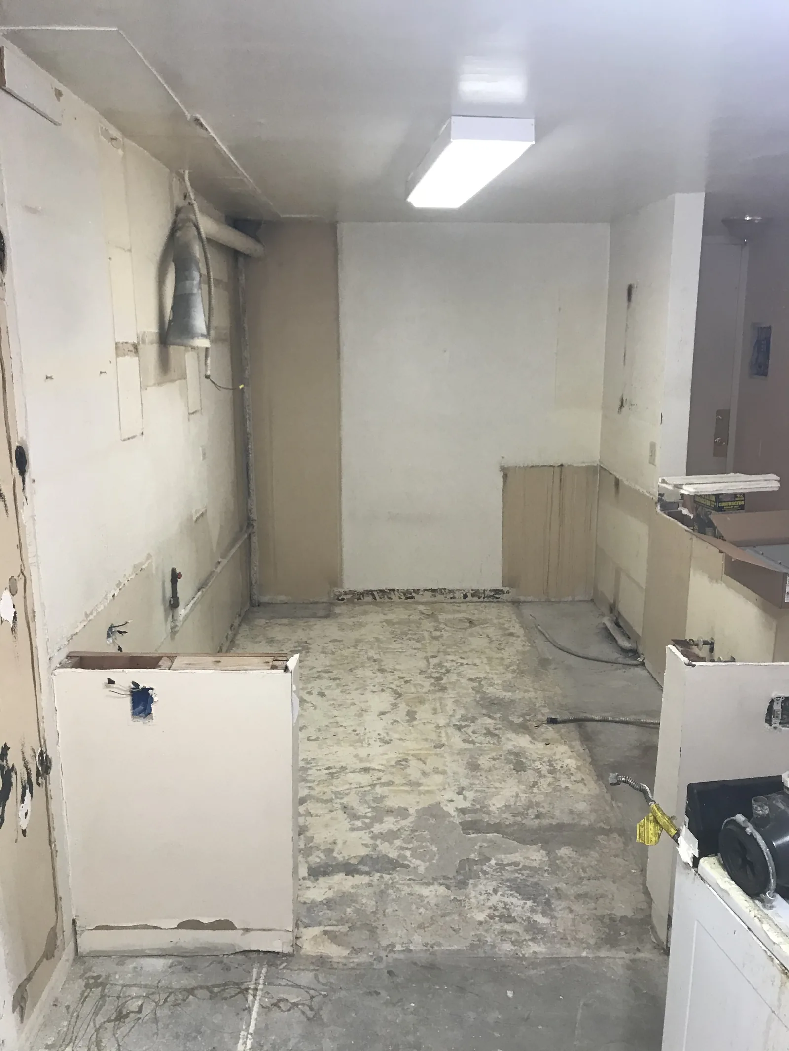 A bathroom stripped down to bare walls and subfloor
