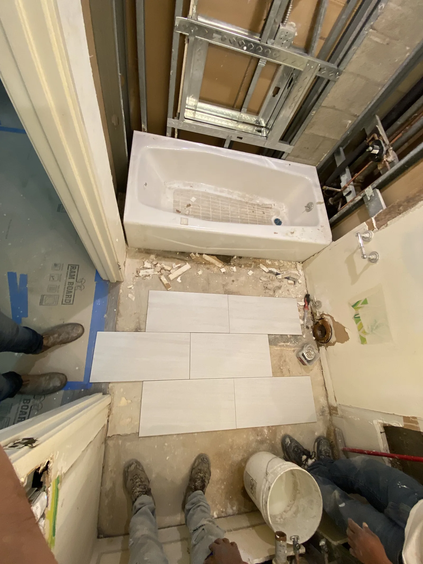 New tile flooring being laid around the bathtub