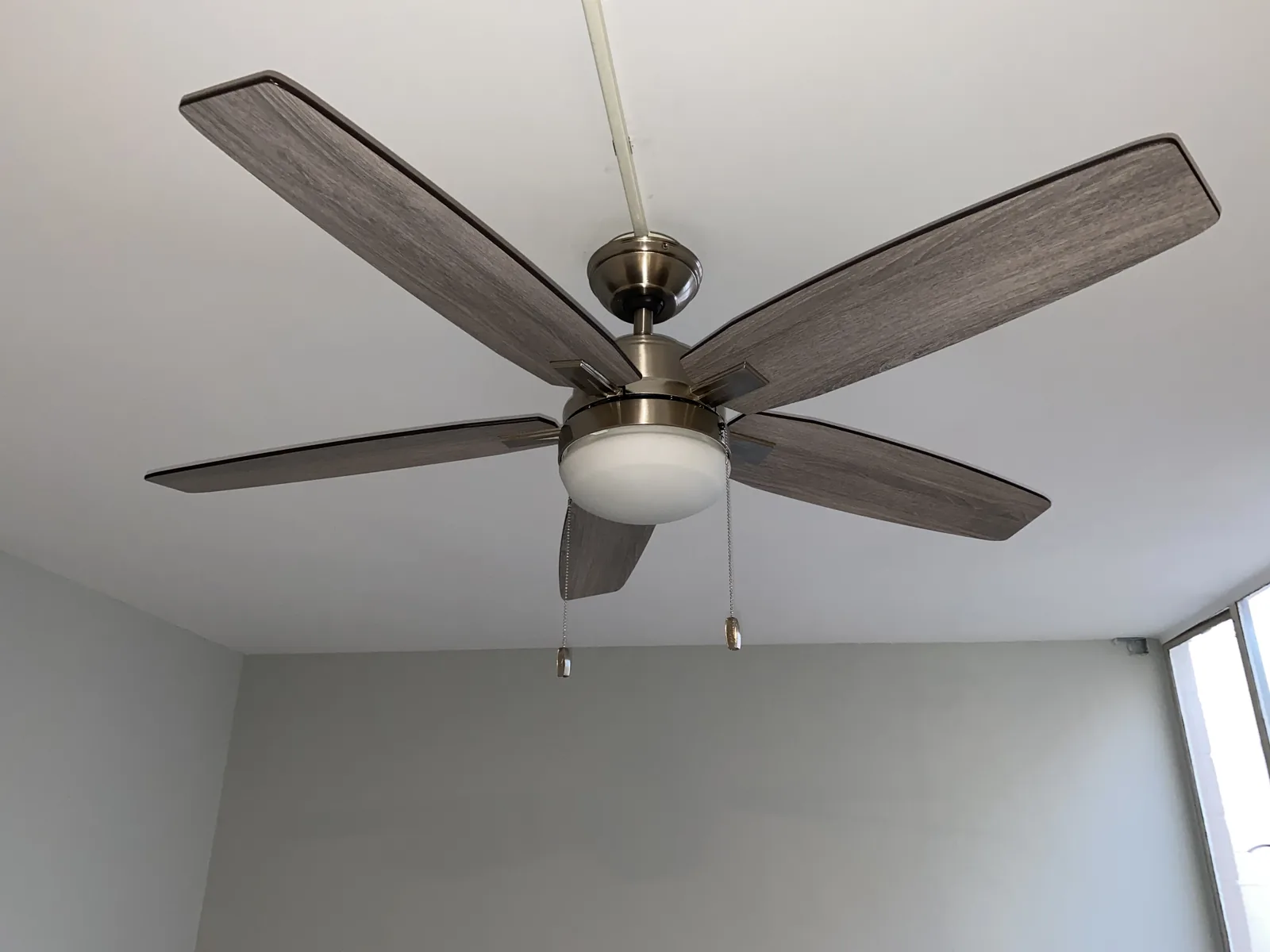 A new ceiling fan installed on a freshly painted ceiling