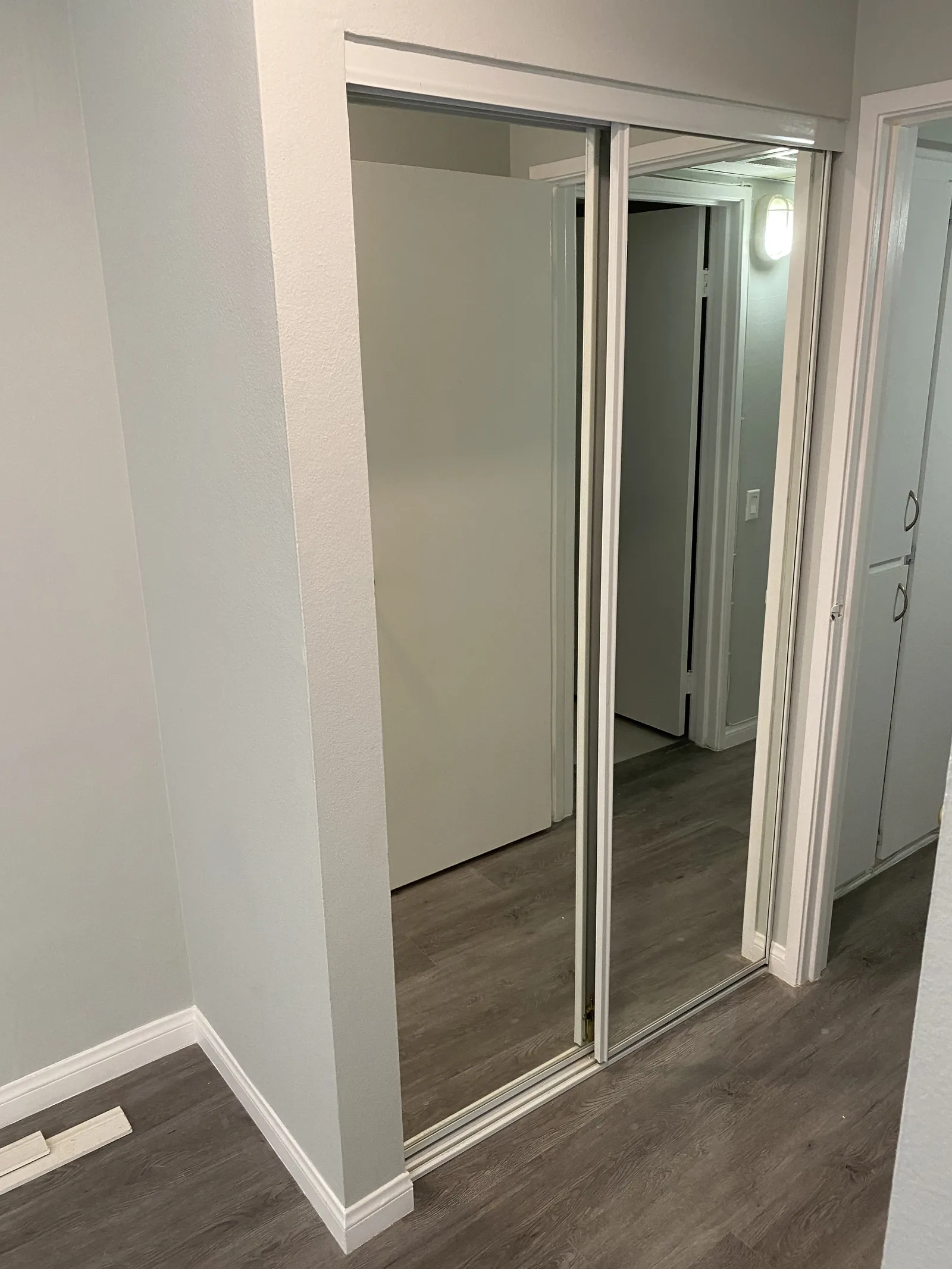 A closet with new mirrored sliding doors and new flooring