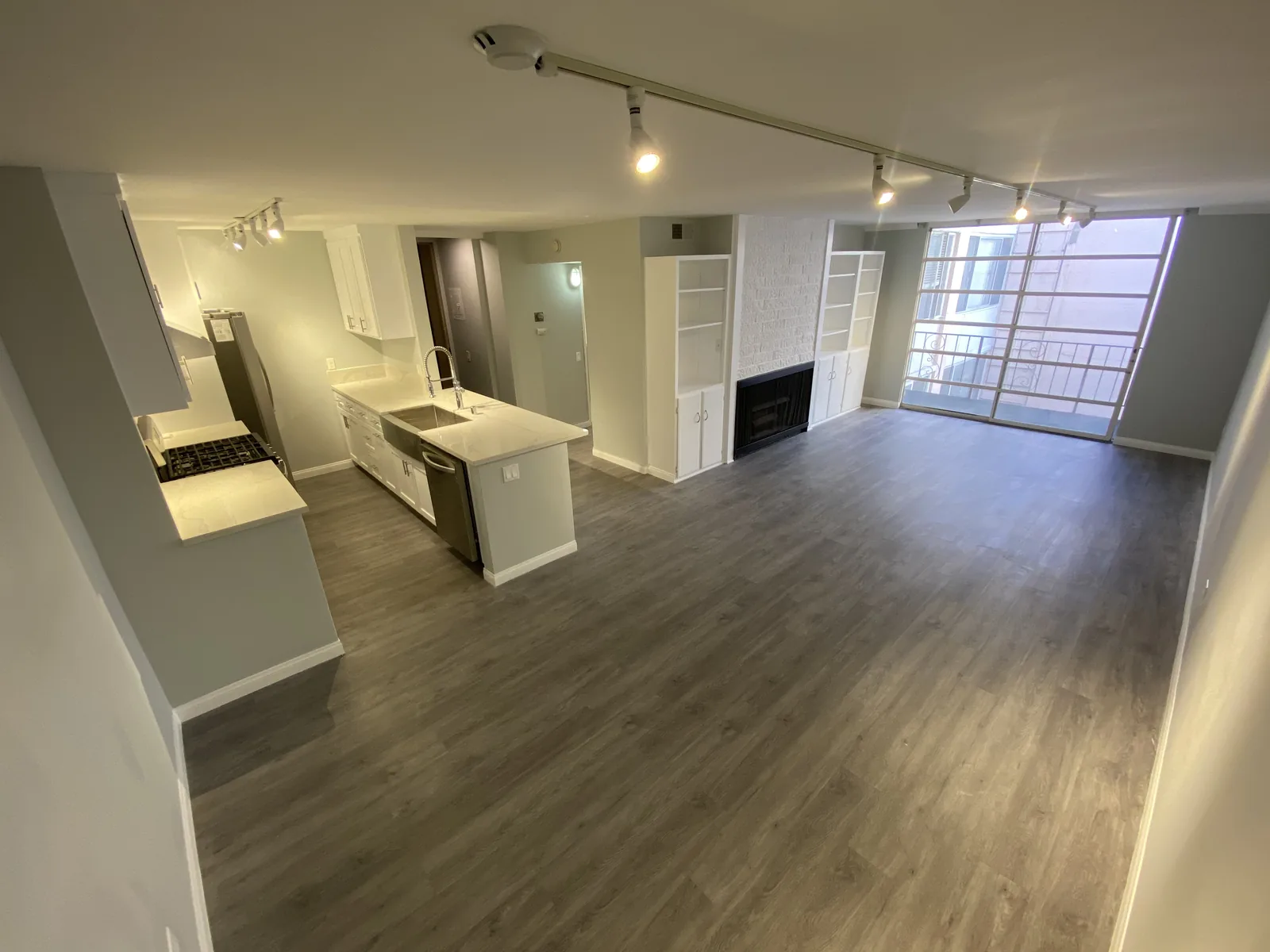 A wide view of the finished kitchen and living room with natural light