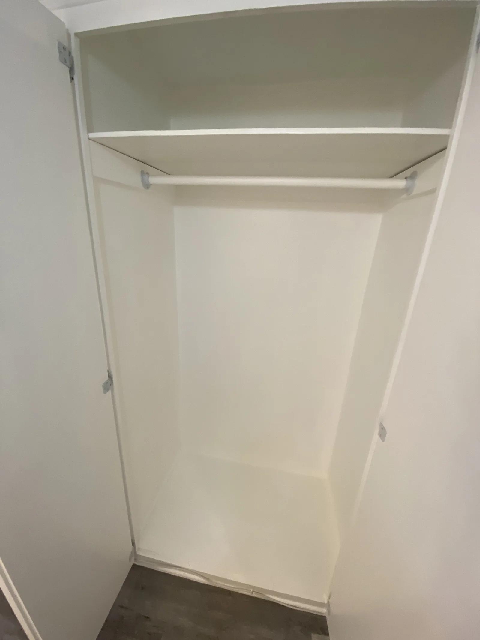 A finished closet interior with a new shelf and rod