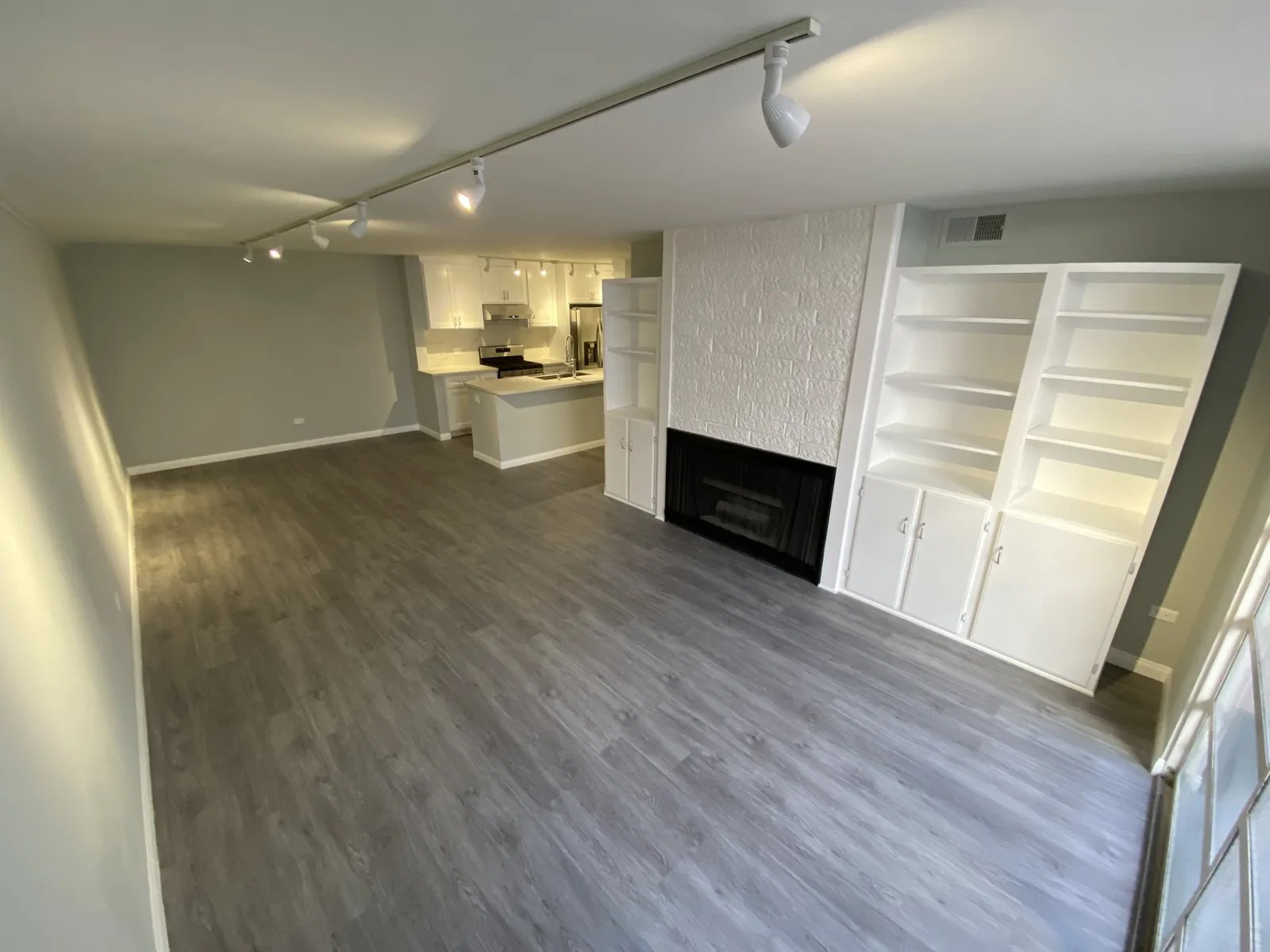 The finished living room with built-in shelving around the fireplace and new flooring