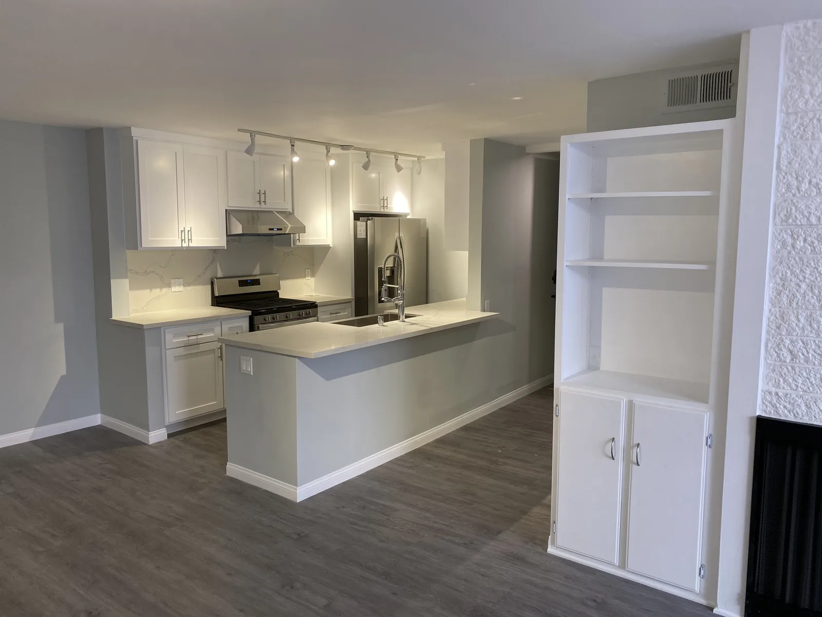 The finished kitchen with white shaker cabinets and stainless appliances